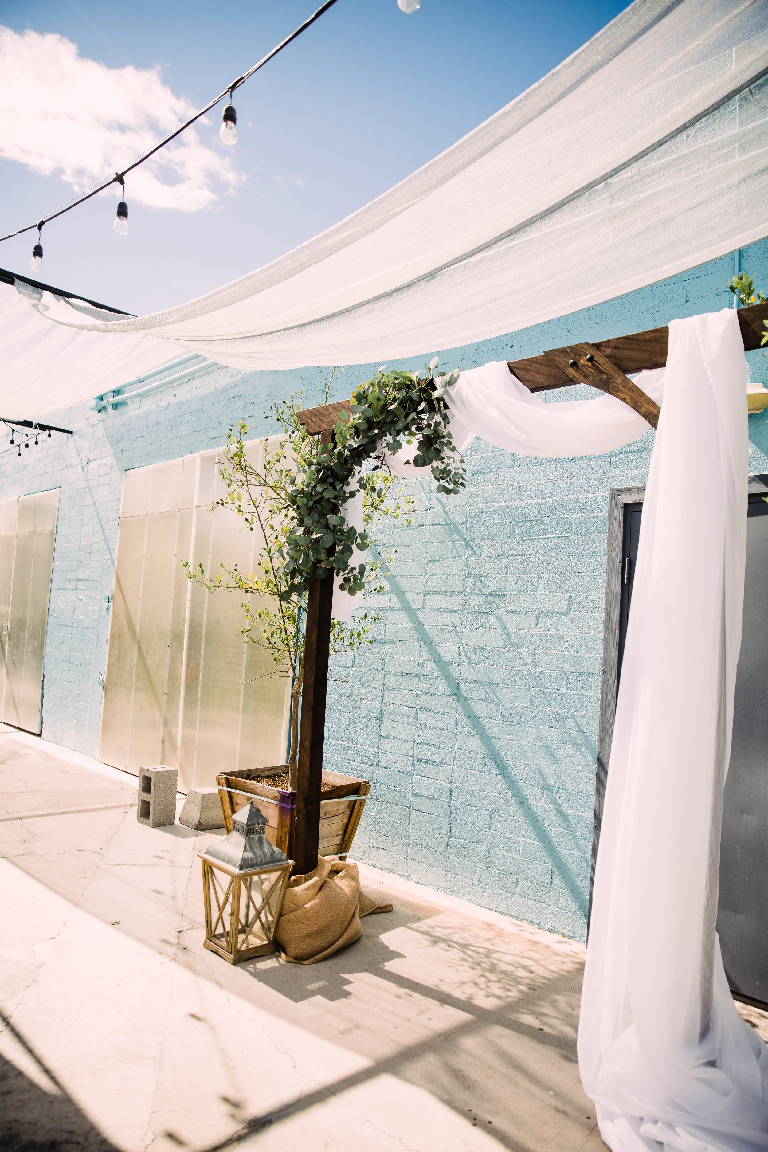 Draping white sheets, string lights, and a modern chic arch.