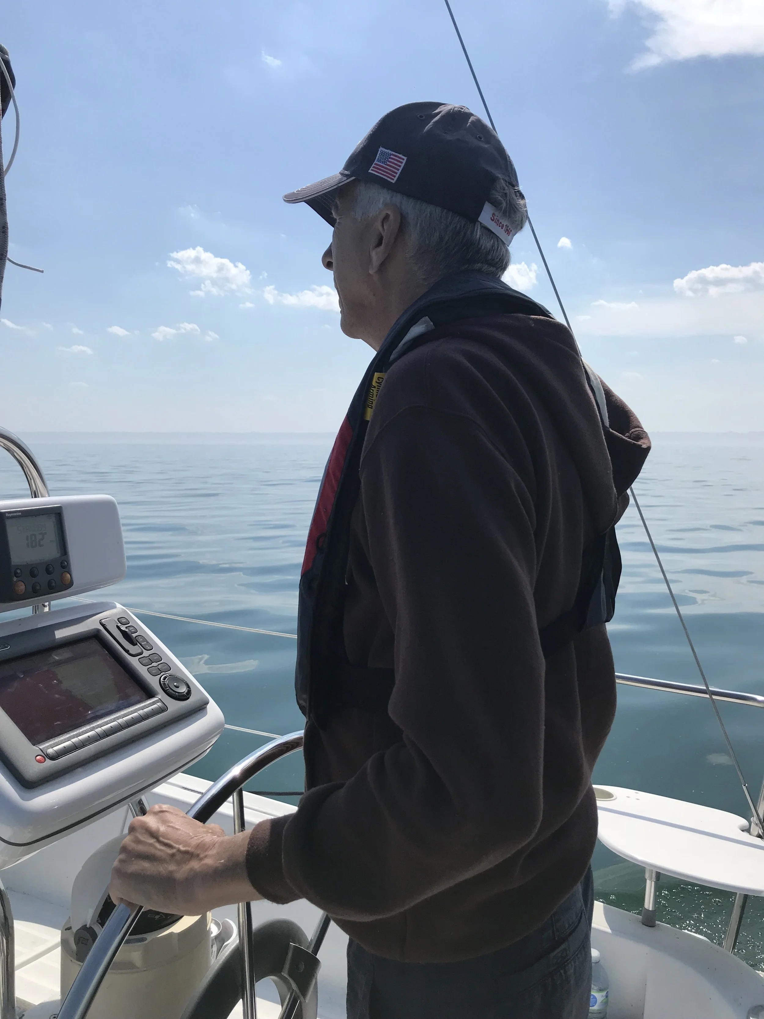 The author's father, Admiral Jim, at the helm of Knot Write.