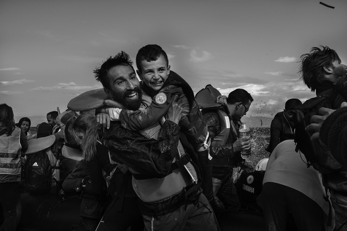  Kadoni Kinan, 26, a volunteer, helps a young Syrian boy as he disembarks a boat near Scala, on the island of Lesvos, Greece on September 30, 2015. Kadoni Kinan left his home in Saragep, Syria five years ago. Kinan successfully filed for refugee stat