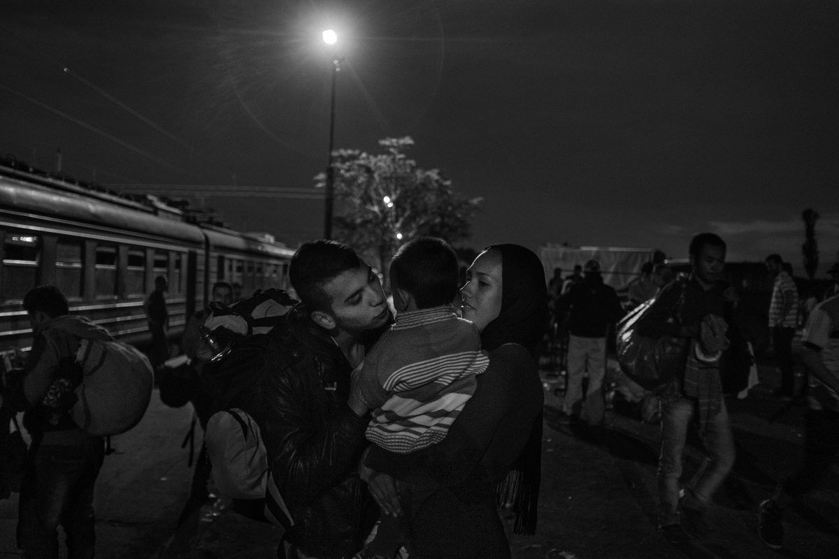Mushawa Mosani-Akberi, 15, kisses his brother, Sajar, 1, being held by Razeer, a relative, before making his way to the Serbian border on October 4, 2015. Mushawa has been traveling from his home in Ghazni, Afghanistan for the past two weeks. He hopes to end his journey in France, where he dreams of becoming an architect. His parents could not afford the journey and remained behind in Afghanistan. The train, which is decades old and run down, takes five hours and costs each refugee, adult or child, €25.
