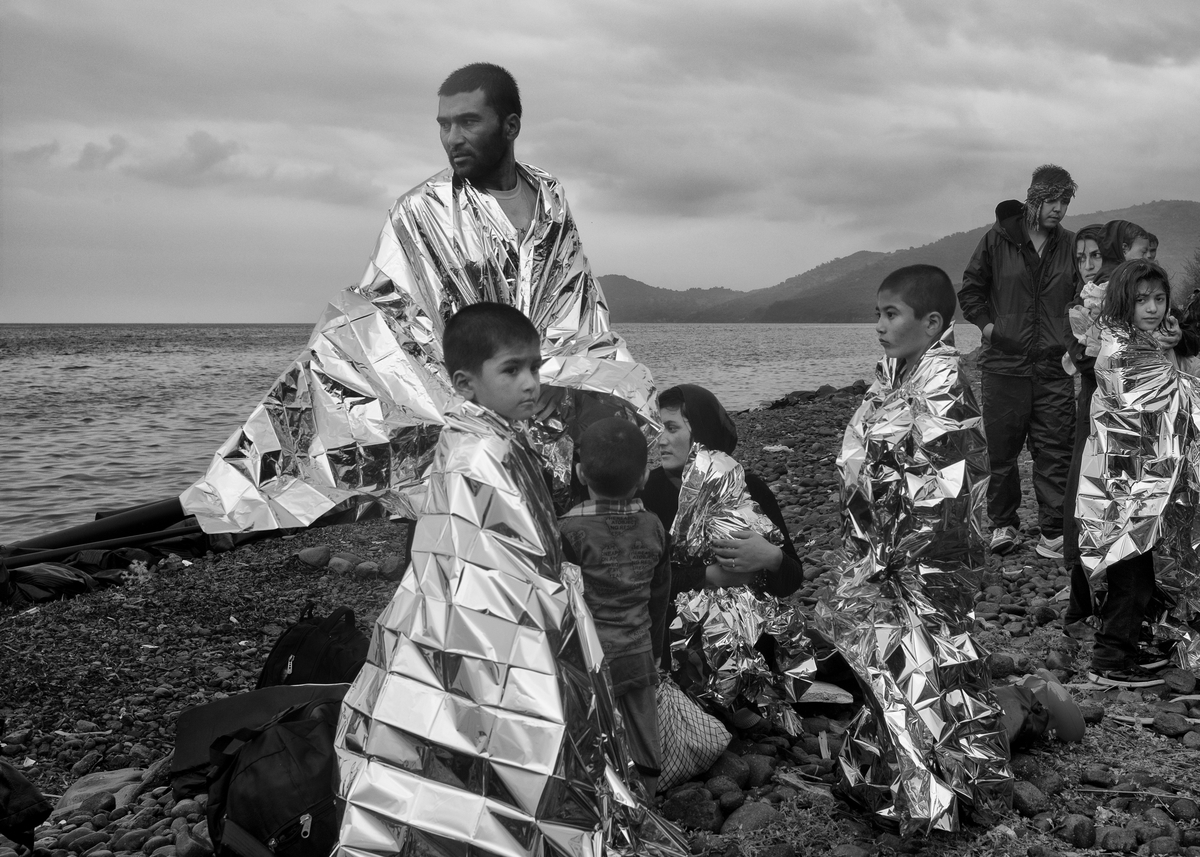 Refugees rest on the coast of the Greek island of Lesbos after crossing through Aegean Sea from Turkey in rubber boats on September 23, 2015.