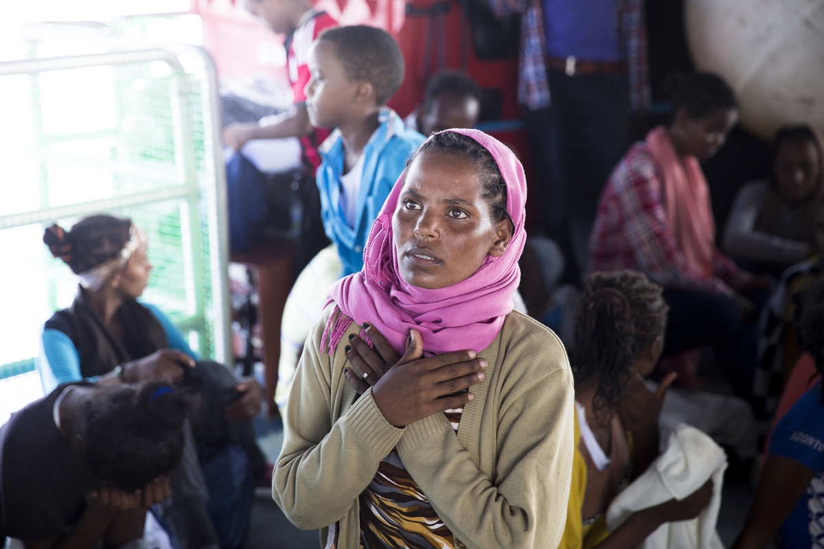  Strait of Sicily, September 2, 2015, a woman praying after been rescued. 40 miles from the Libyan coast , MOAS/MSF Holland team are rescuing two old wooden boat coming from Libya with 550 people on board. All the refugees in these boats where coming