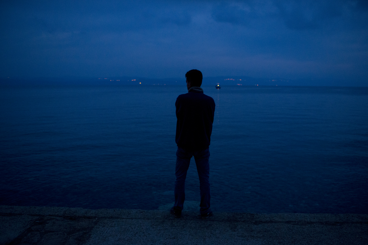  A refugees looks towards Turkey after arriving on the Greek island of Lesbos. 