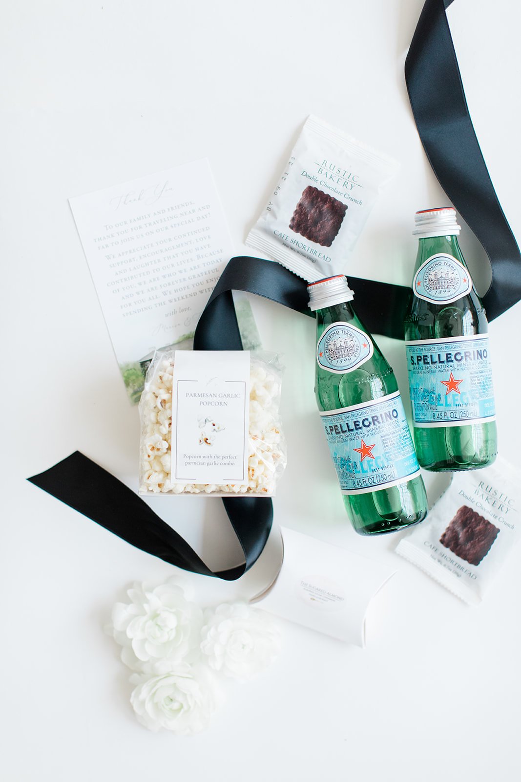 popcorn, drinks, ribbon, chocolate snacks in wedding welcome box