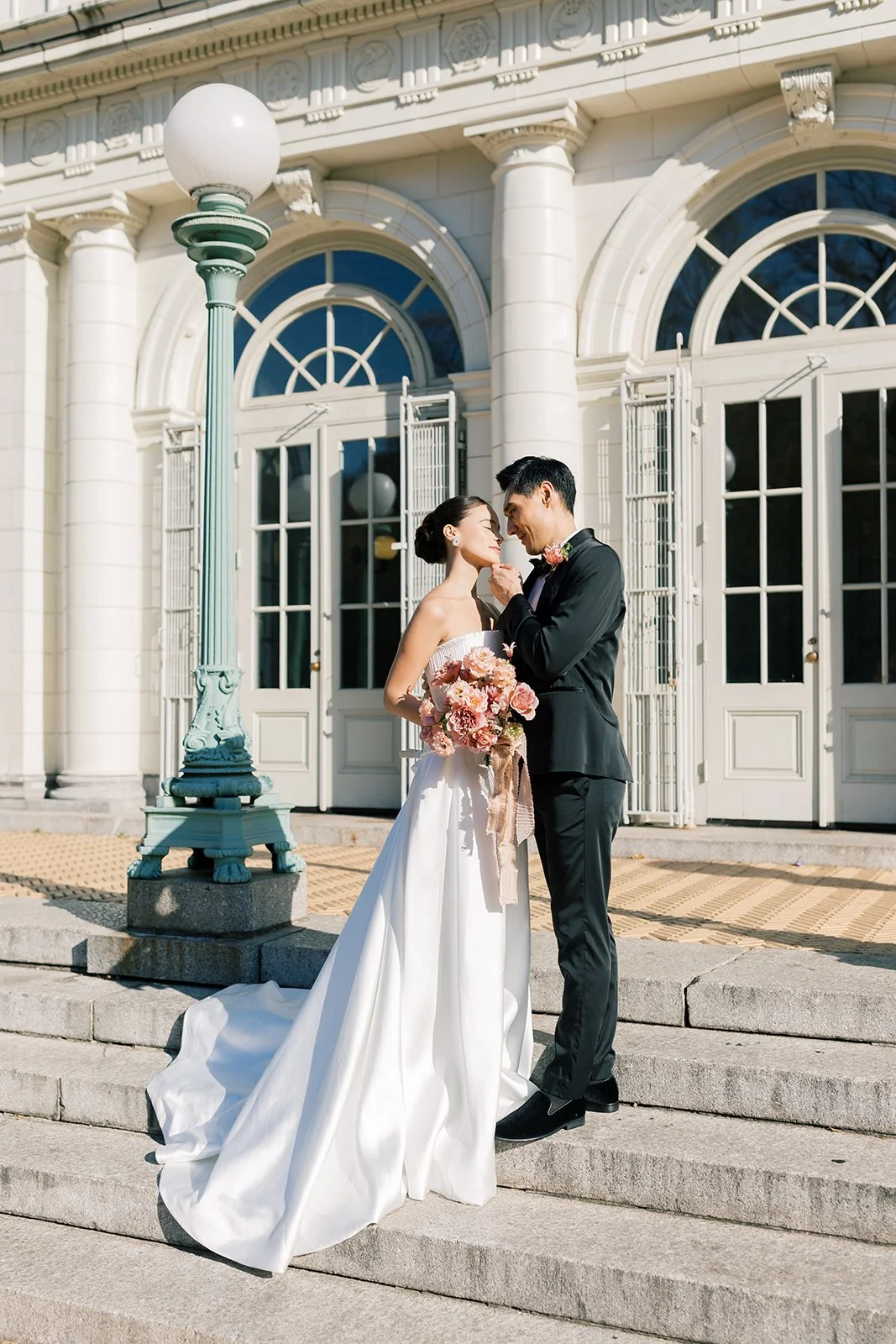 couple standing in front of brooklyn boathouse for wedding with gorgeous mauve florals