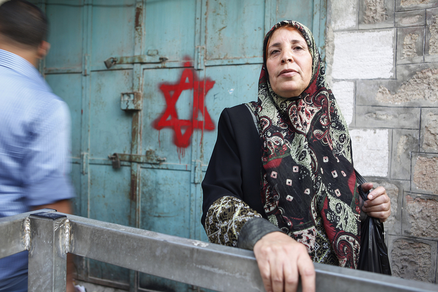 6 A Palastinian woman stands by a building in Herbron, which has been marked with the Jewish cross to sybolise Jewish ownership, West Bank .jpg