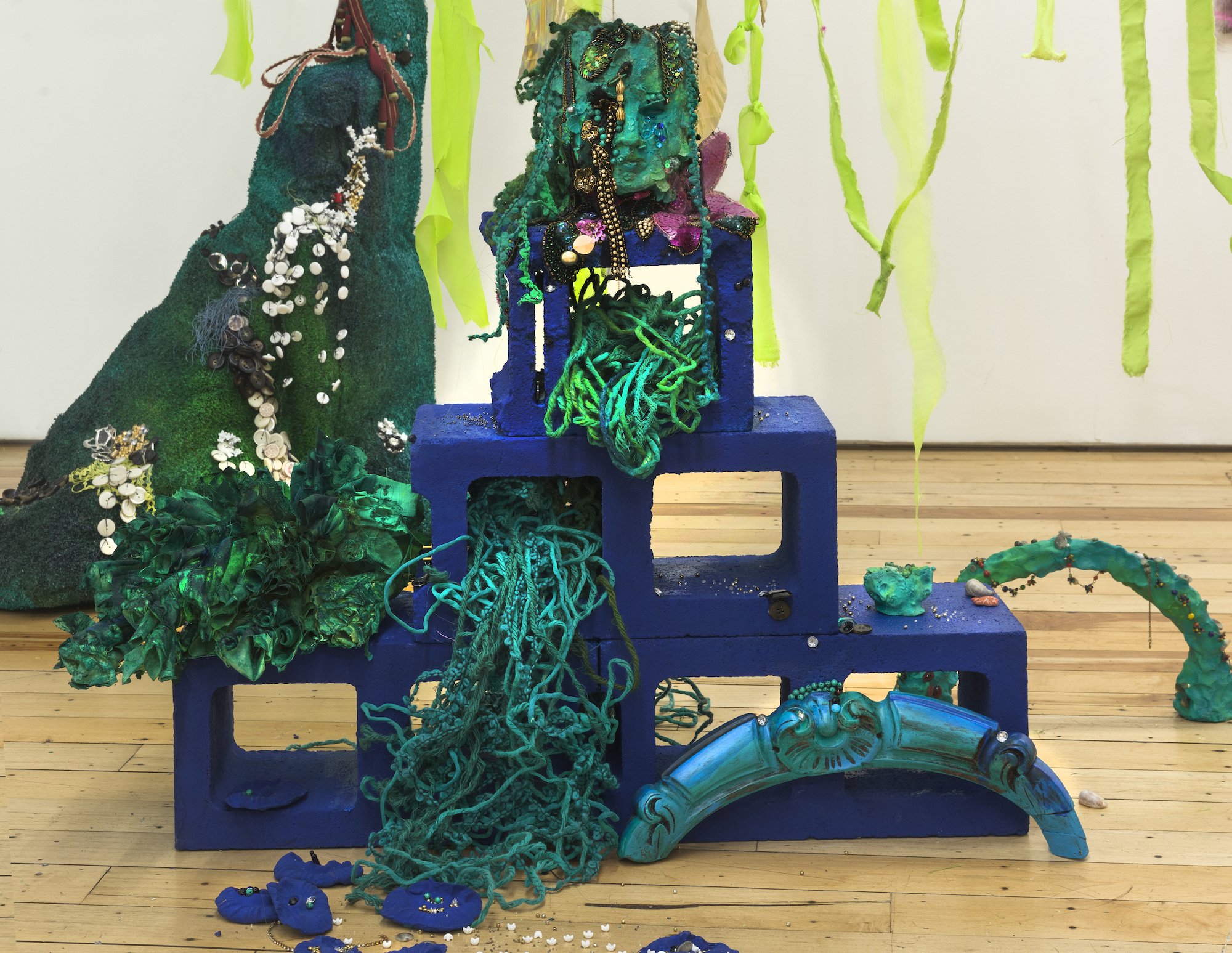 "she waits inside the pause (6)," 2023,
clay, astroturf, paint, sequins, trim, beads, buttons, yarn, cinder blocks
, 32 x 42 x 36 in
