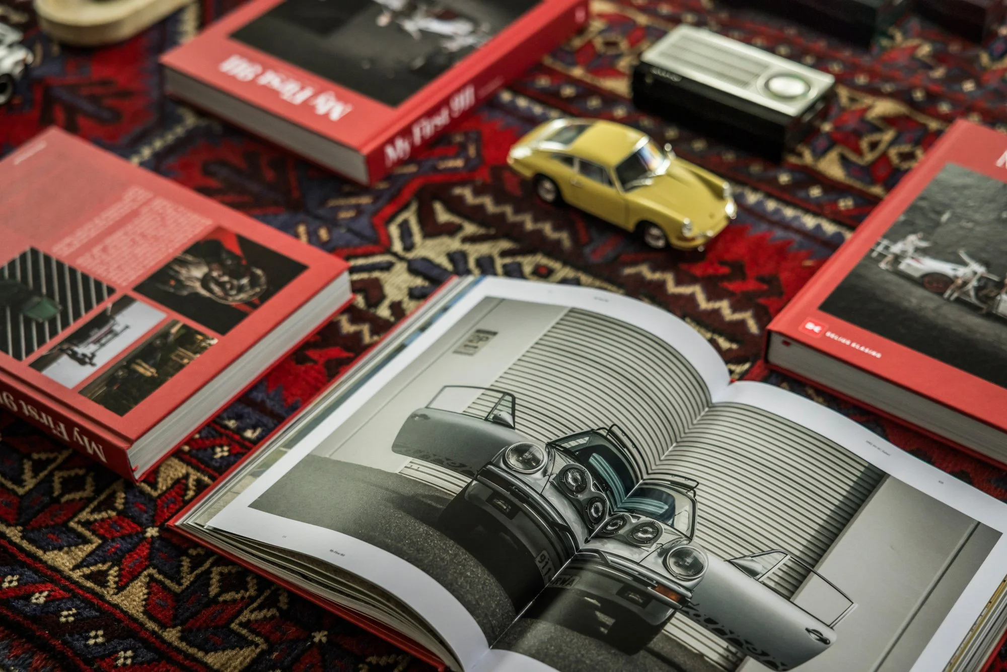 photo of Kai Hartmann's 'my first 911' coffee table, Book laying on a persian carpet