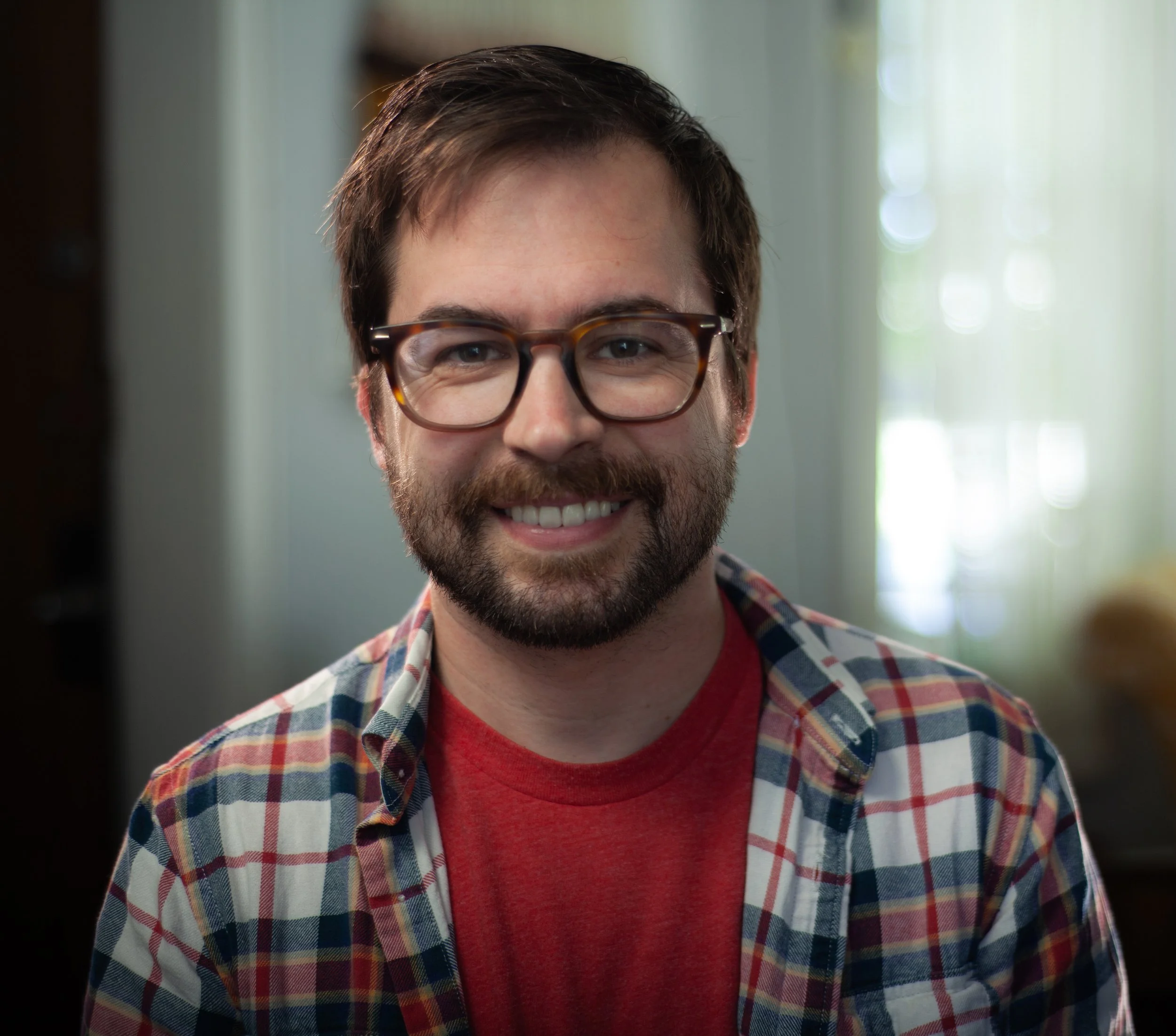 image of jonathan moeller - a man with brown framed glasses, facial hair and smiling at camera