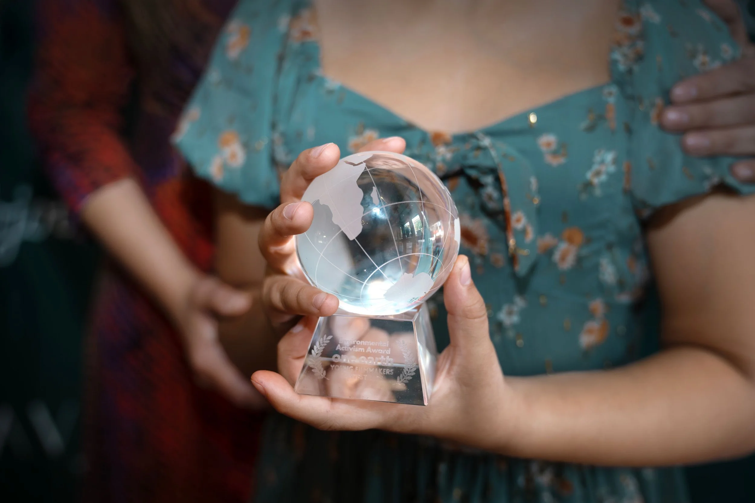 student holding a crystal globe award