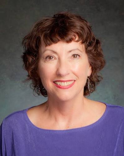 Monica Fox - a woman in a purple shirt smiling at the camera