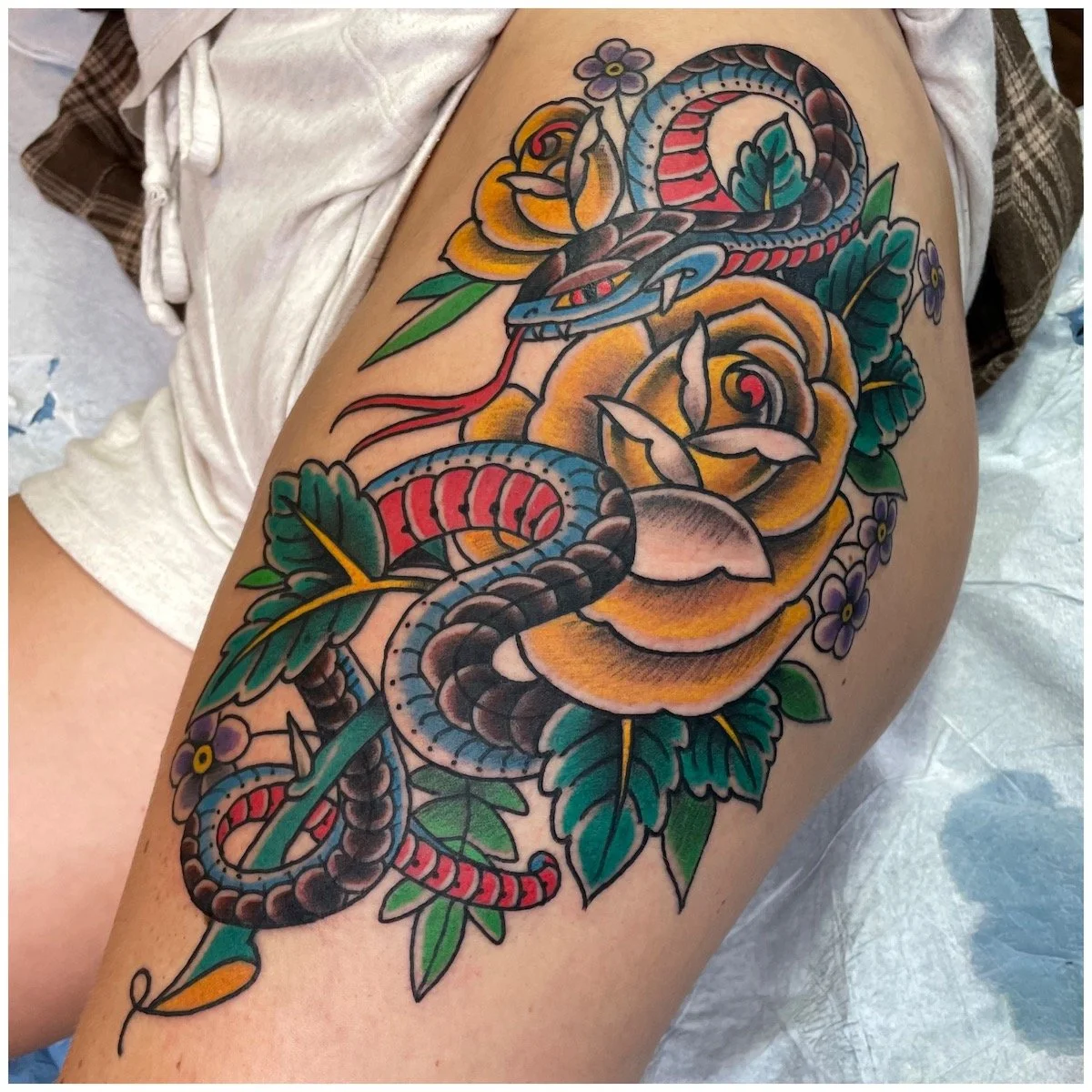 traditional snake and rose tattoo on a hip made at remington tattoo in san diego 