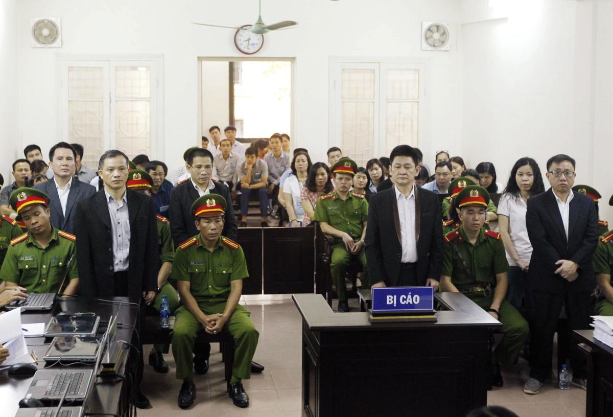 Nguyễn Văn Đài (left) and other political activists stand in a courtroom during their trial in Hanoi on April 5, 2018. (Photo: AFP/Vietnam News Agency)