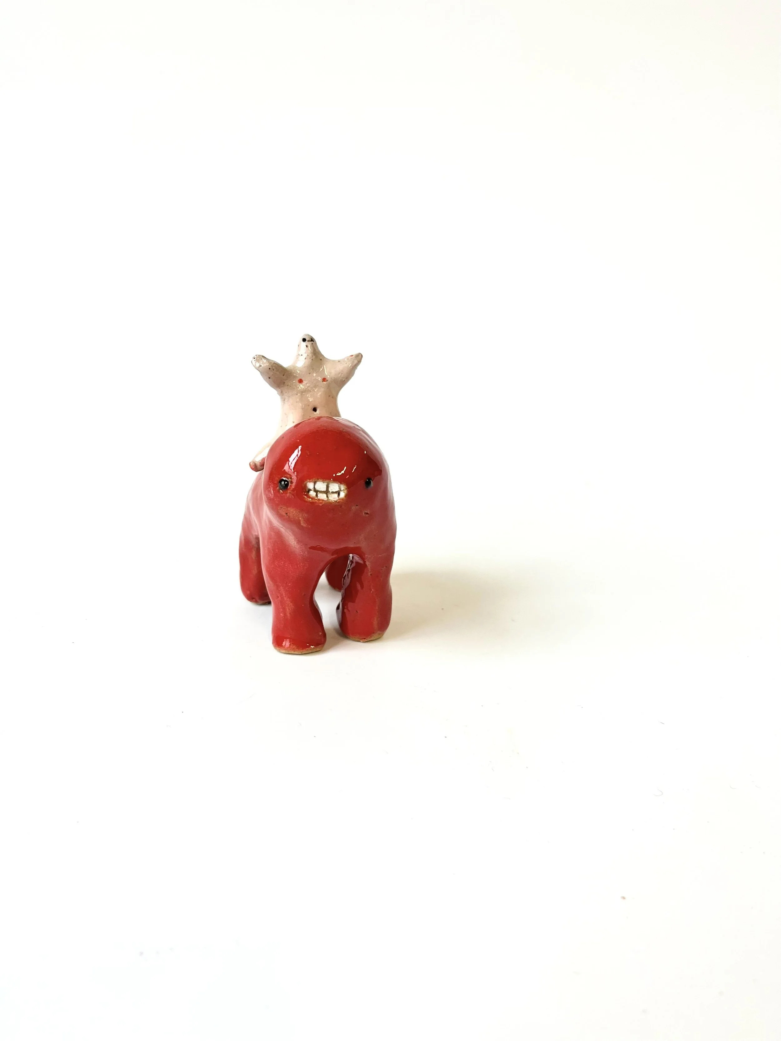 Mini Teethie, with a happy naked weird little man on its back