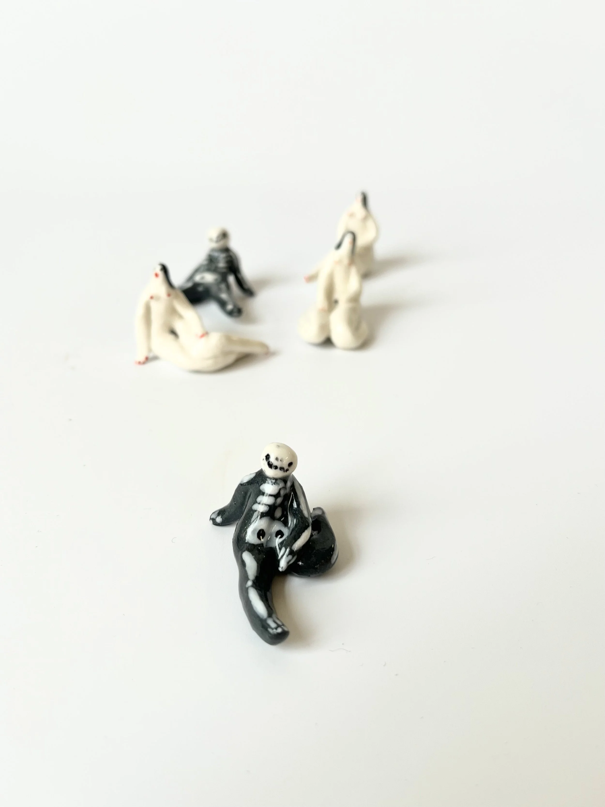 Tiny ceramic skeleton figures