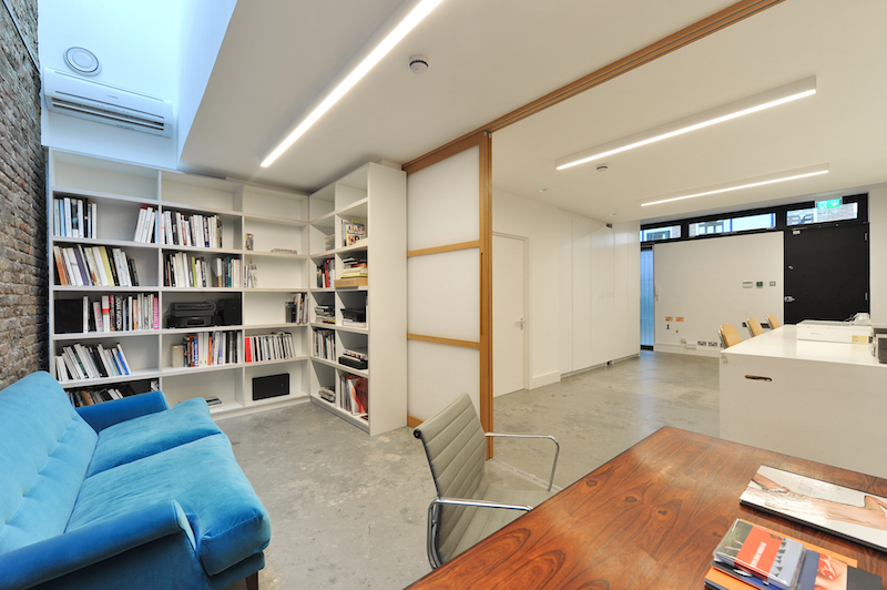 OUR TAKE: This photographer’s studio was a large, open-plan space that needed to be an office, a studio and a relaxing space all at once. We created a private space that could be partitioned using full-height oak and translucent panel doors. Soft furnishings in soft colours also helped make the space feel calm and quiet.