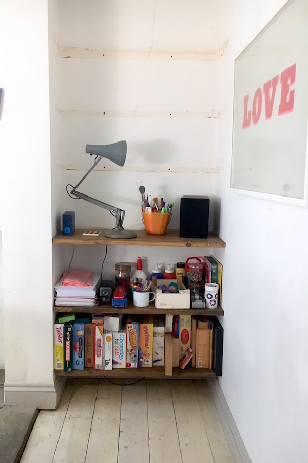 An 'after' photo of a clean, decluttered and less filled with 'stuff' bookcase in a family home.