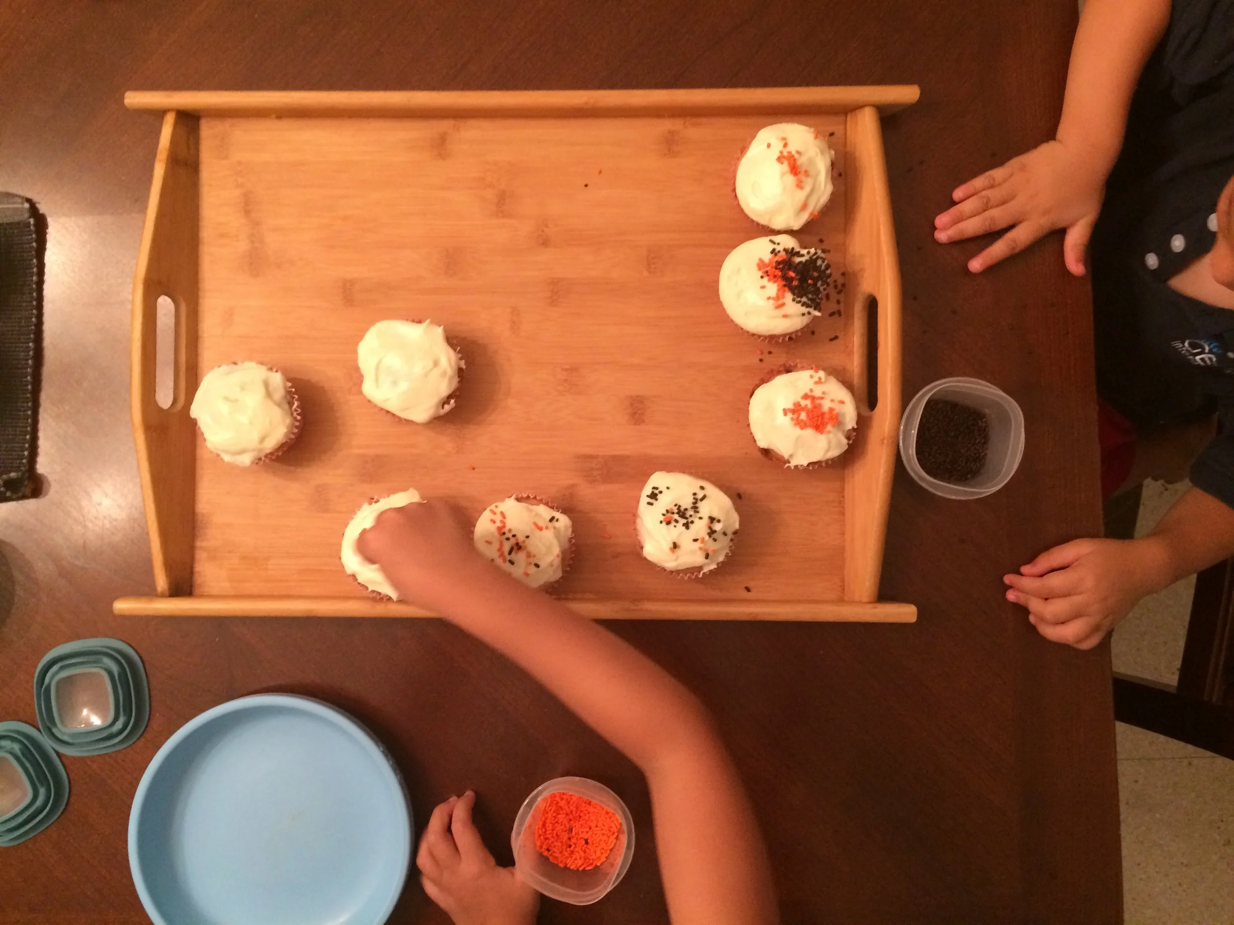 My kids decorating chocolate chip muffins with cream cheese frosting. 