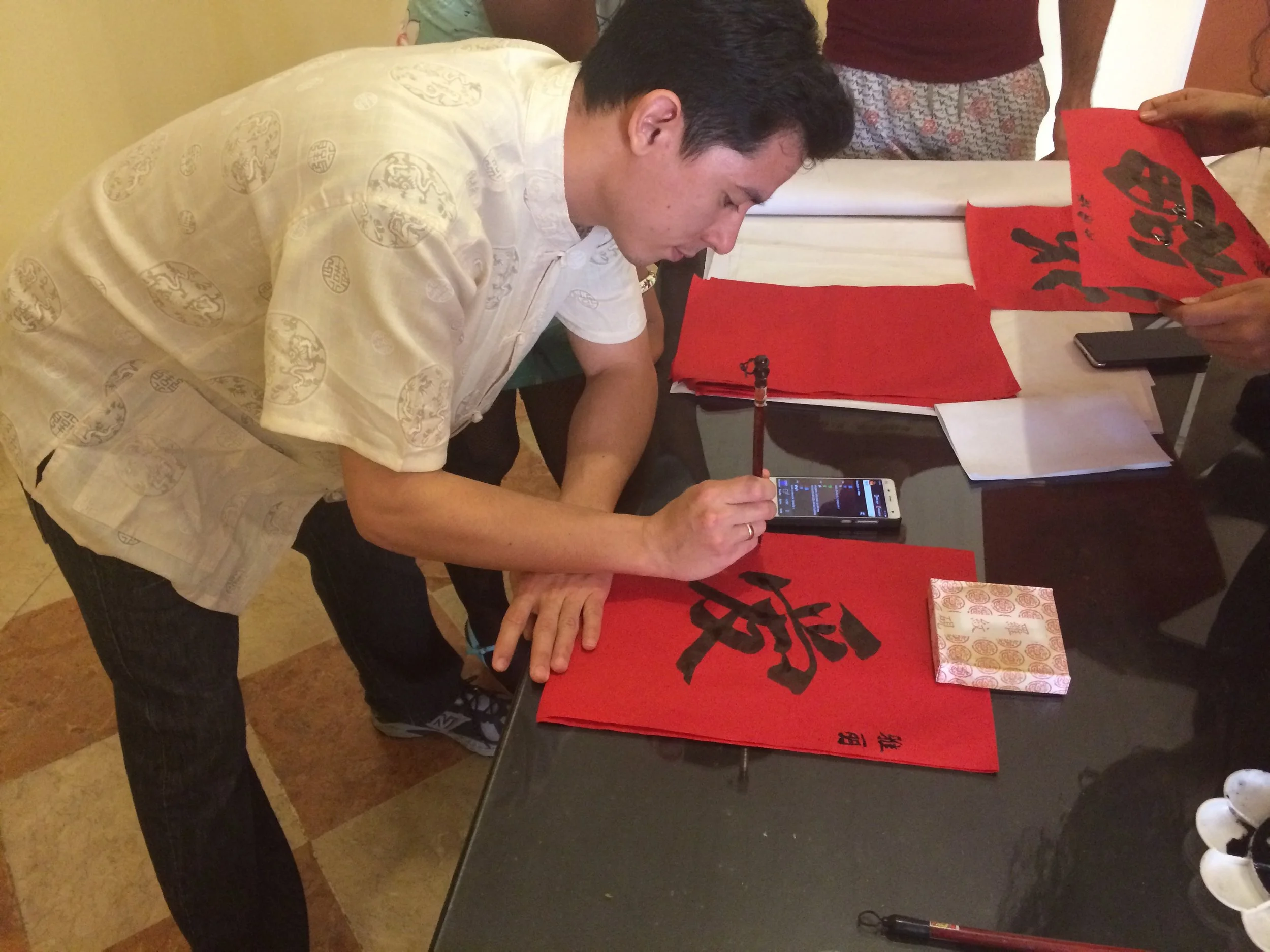A student named Fidel painting calligraphy for my daughter. 