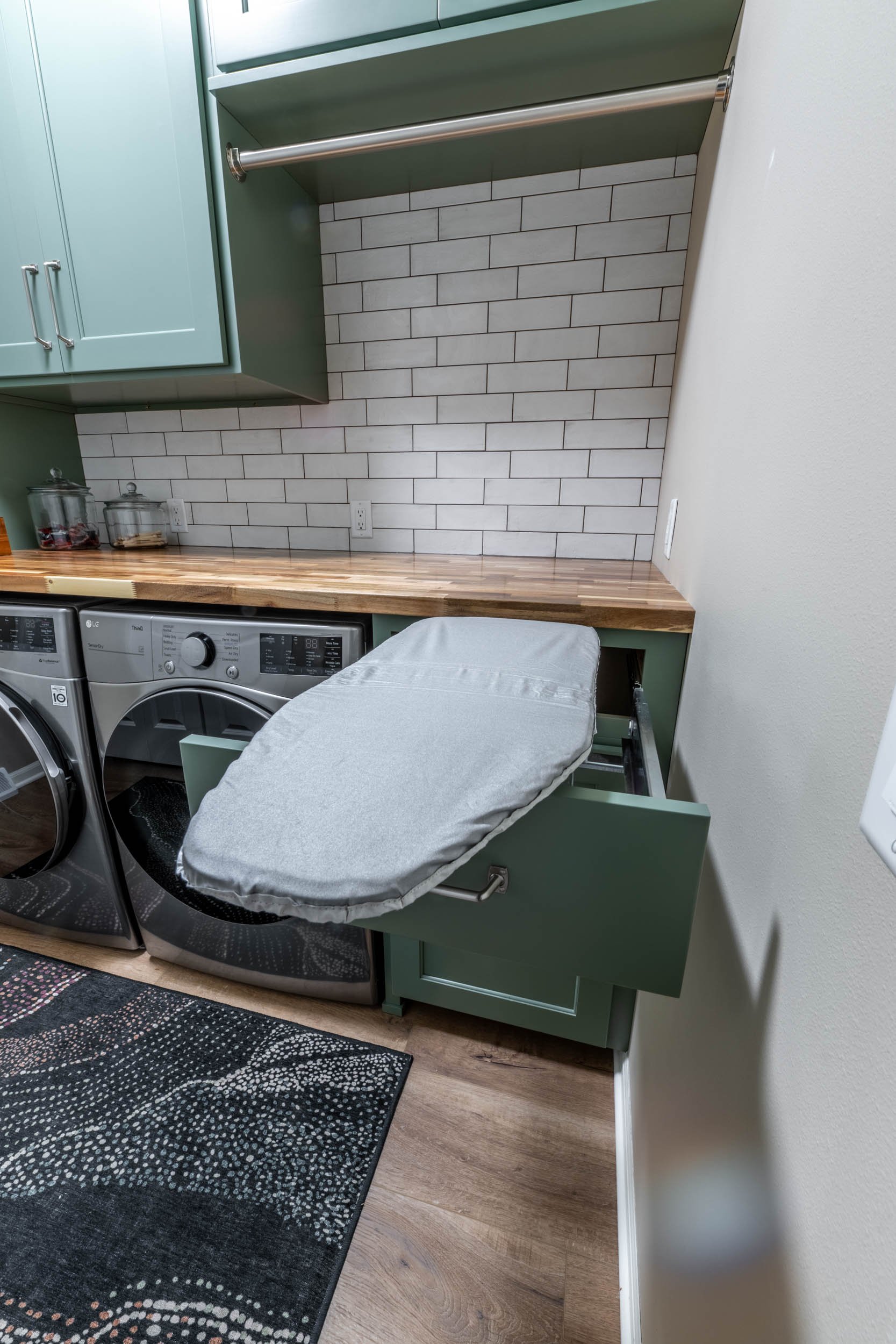 The lower cabinet contains a folding ironing board.