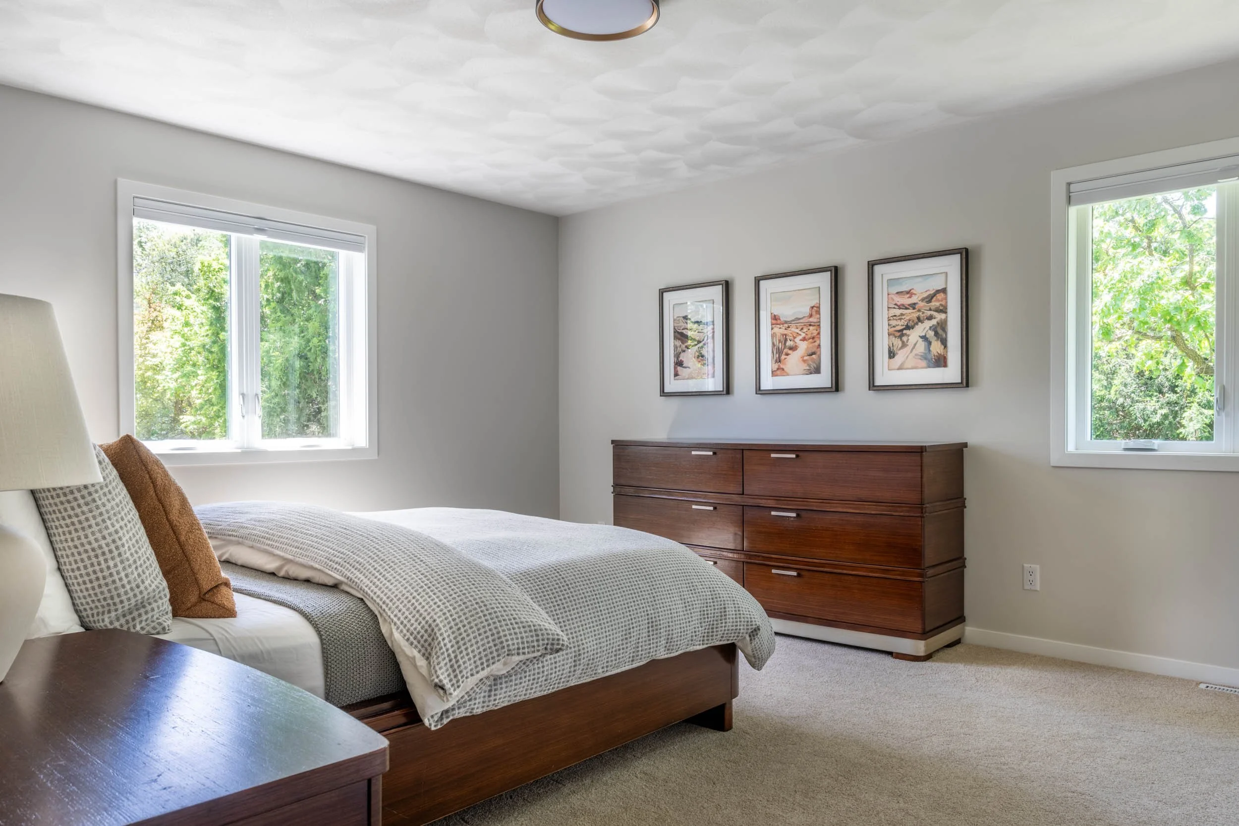 Overall view of the primary bedroom, highlighting the new carpet, base trim, windows & casing