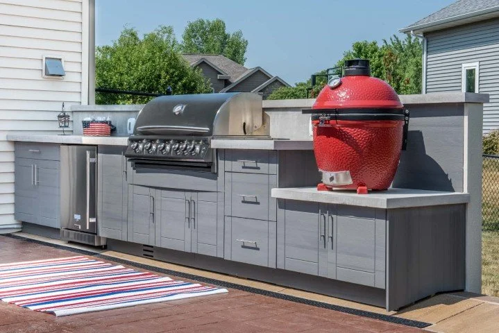 Grey outdoor kitchen with stainless steel gas grill and Red egg grill
