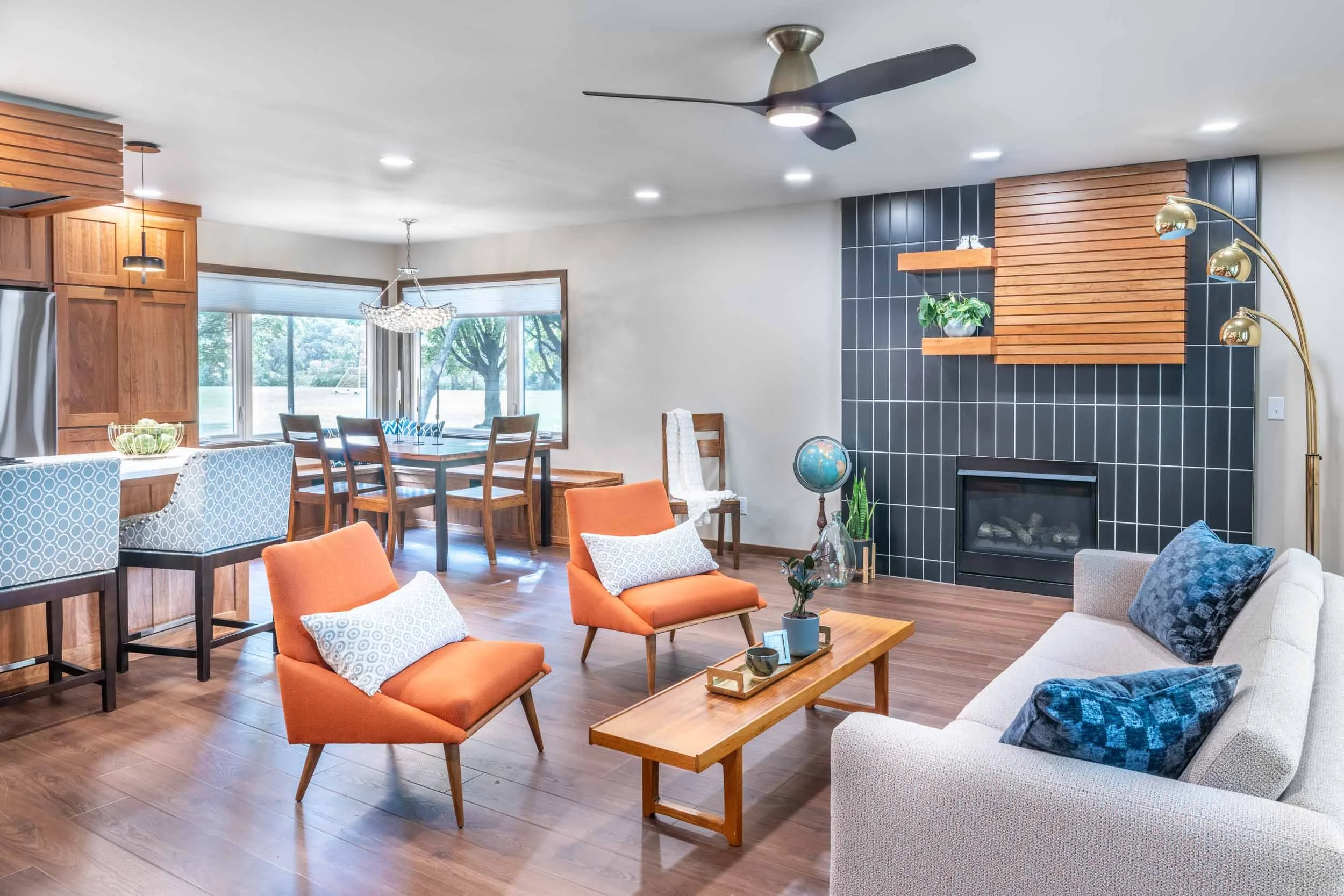 Midcentury remodeled home with black vertical fireplace tile and slatted cherry cabinets and featured wall over fireplace