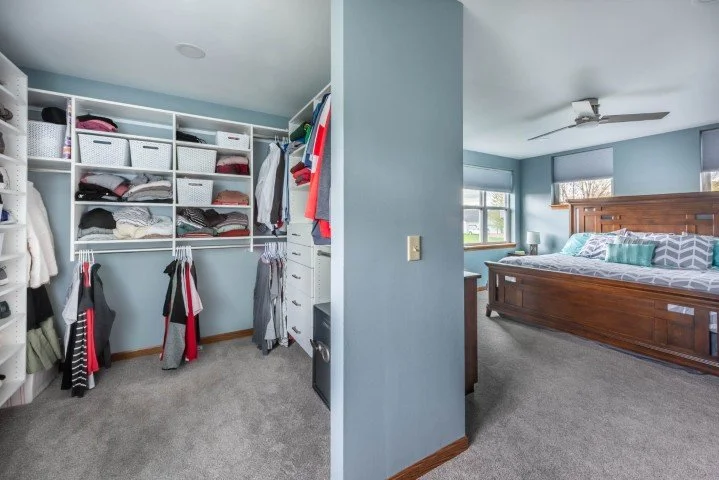 This walk in closet has no door to maximize storage and light in the master bedroom.