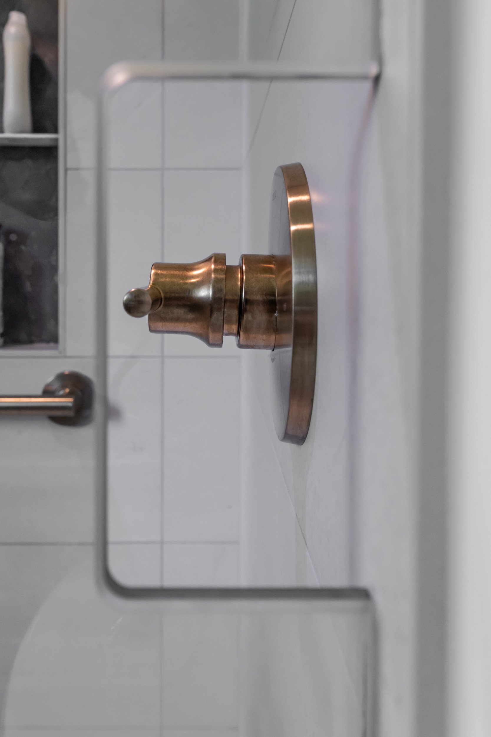Close up view of the hand cut-out in the shower glass to allow the shower to be turned on from the outside