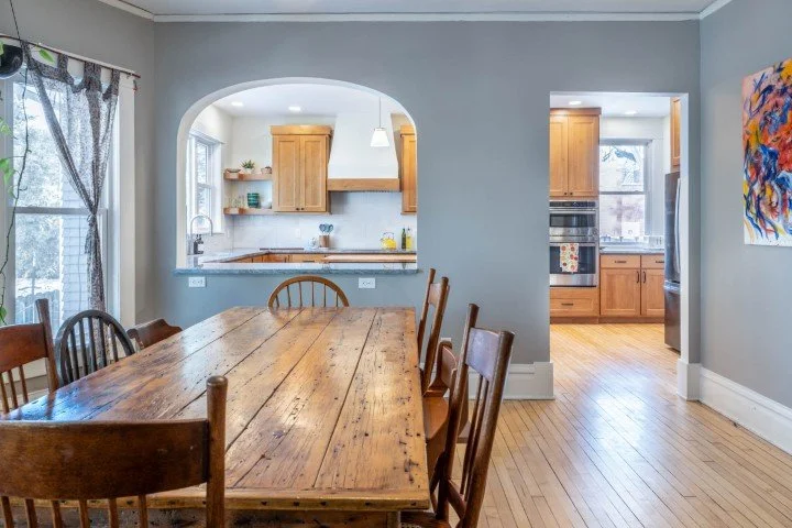 A stained cabinet kitchen and arched opening to dining room