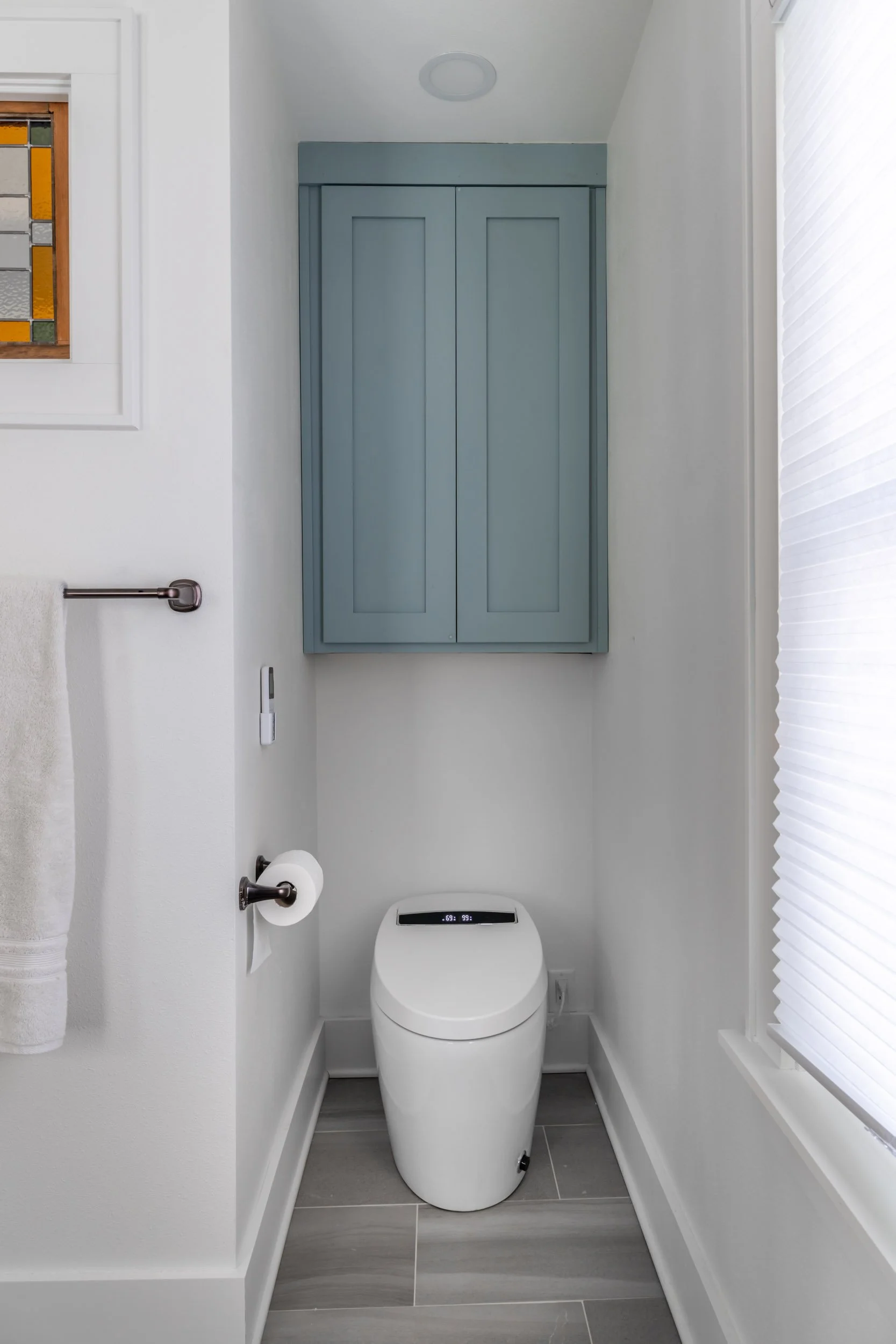 The toilet is a white Bella dual flush model by Miseno.