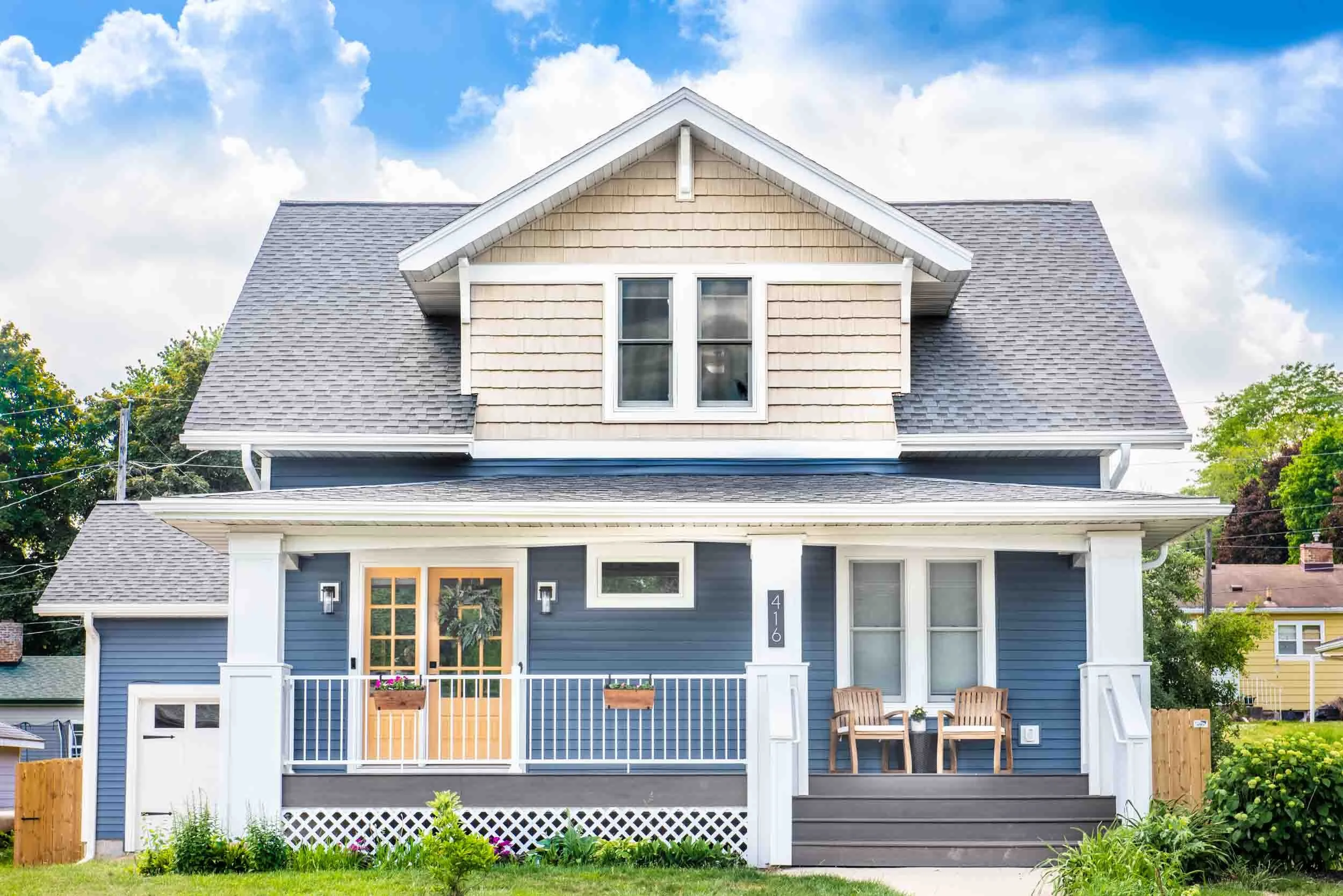 A bungalow makeover with blue siding and white trim and grey porch decking