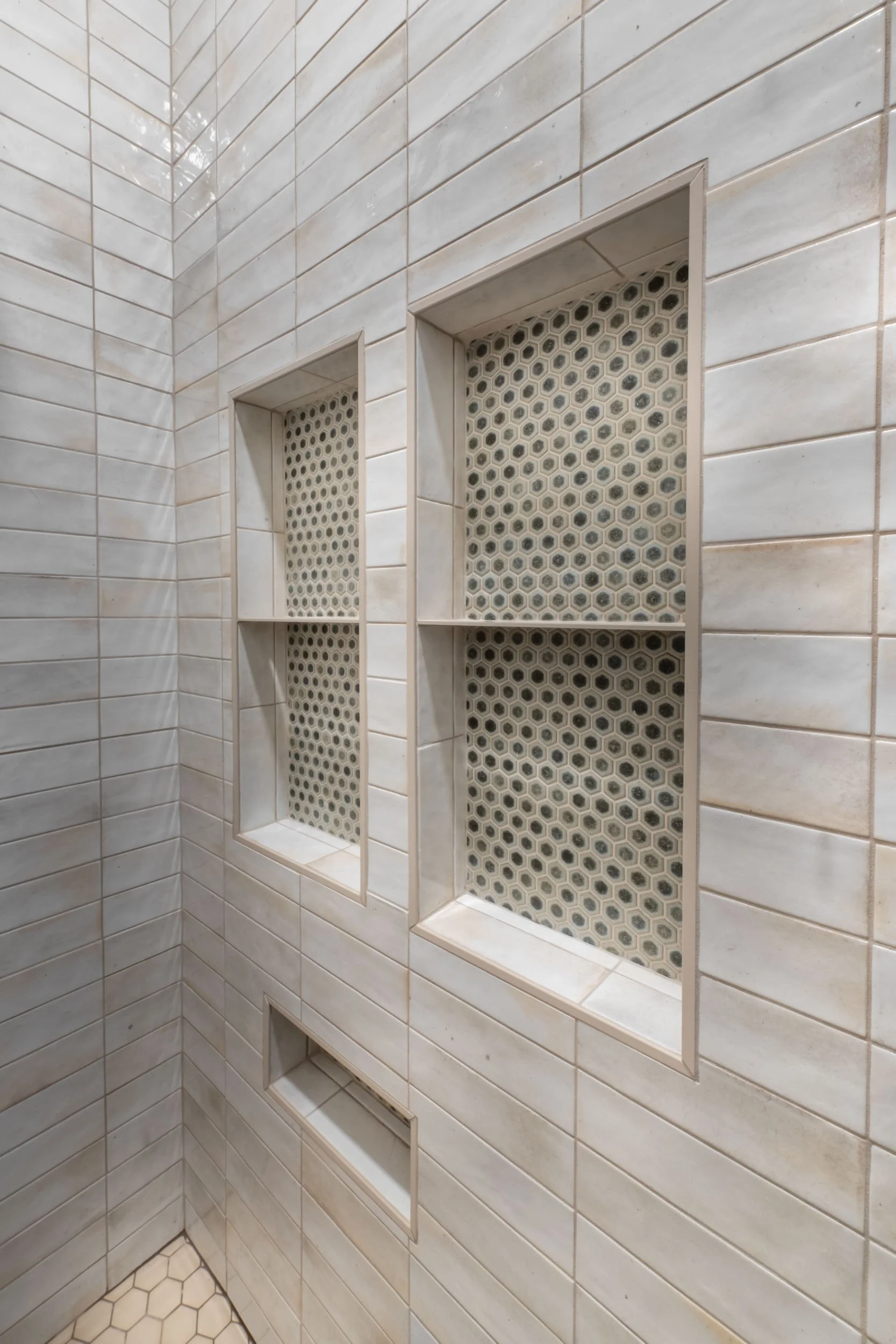 The shower niche has Maniscalo Chameleon hexagon mosaic tile in Sage Green