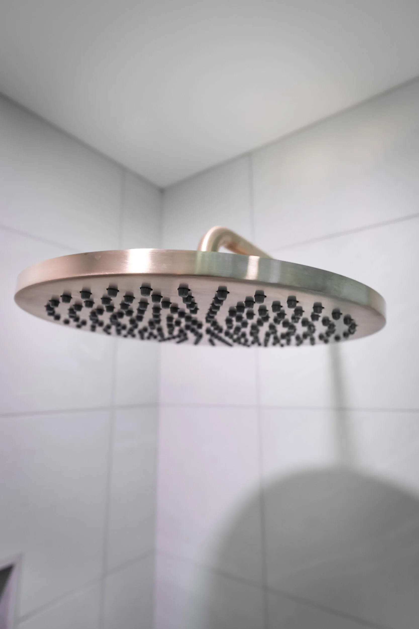 Close up view of the champagne bronze Delta rain head