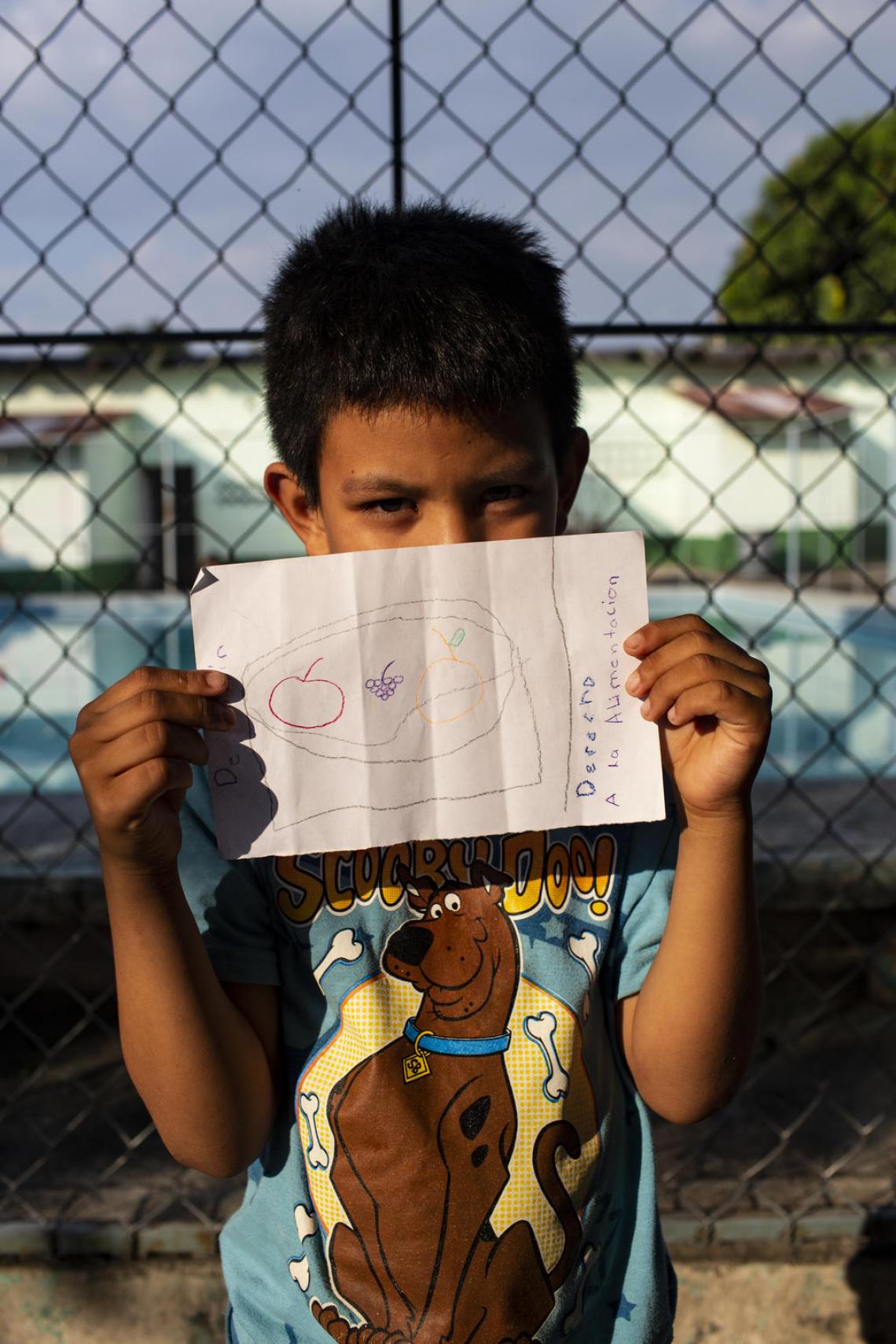 Jahir, 8, from Honduras, shows off a drawing that depicts his right to eat at the St. Augustine hotel for refugees in Tapachula, Mexico. “Whether these children stay in Mexico or head further up north, it is crucial that they remain with their families, that they are kept out of detention centers,” says Paloma Escudero. UNICEF supports the implementation of ’open-door’ shelters for migrant and refugee children, where they receive psychosocial support, education, health services and legal assistance.