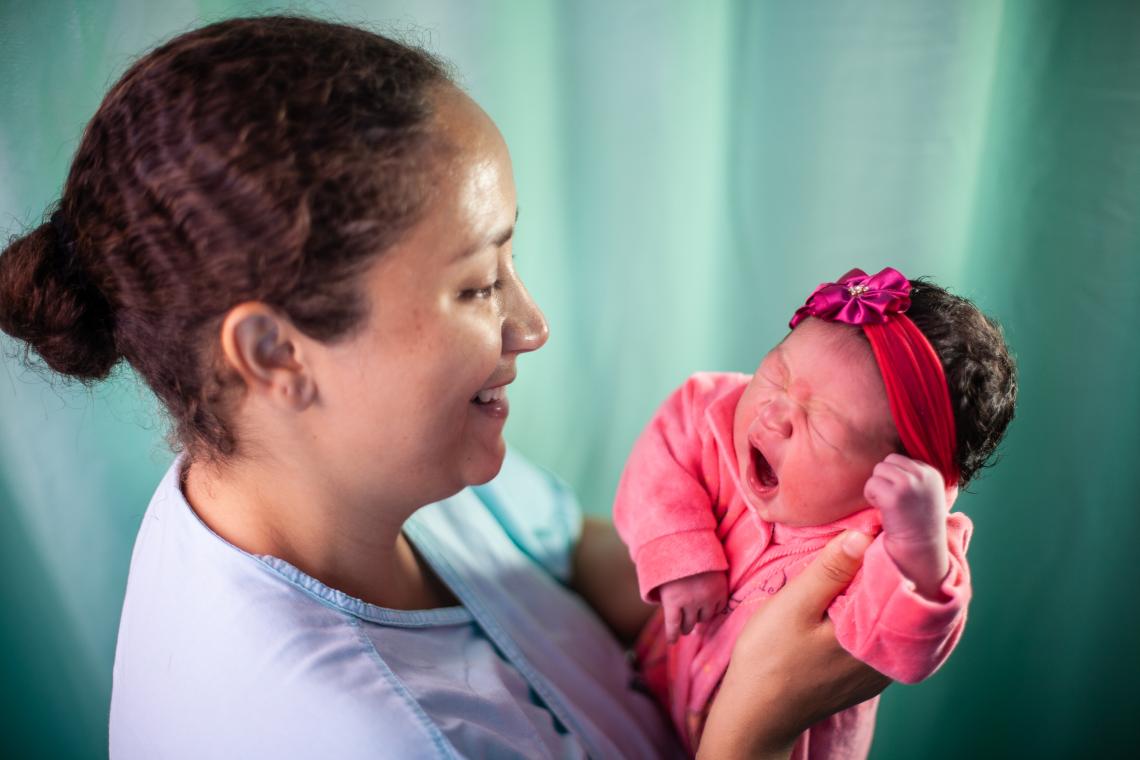 Belo Horizonte, Brazil, 12:01 am: Julia da Silva Reis, 3.9kg (8.5 lbs.), born by caesarian section, greets mother Viviane Dos Santos at the Hospital Sofia Feldman. Father Rafael da Silva says he is very hopeful about providing a future for his daughter. For nearly 30 years, Brazil’s Community Health Agent programme, through which health agents visit families and teach them about the importance of breastfeeding, hygiene and vaccinations, has been significantly reduced under-five child mortality.