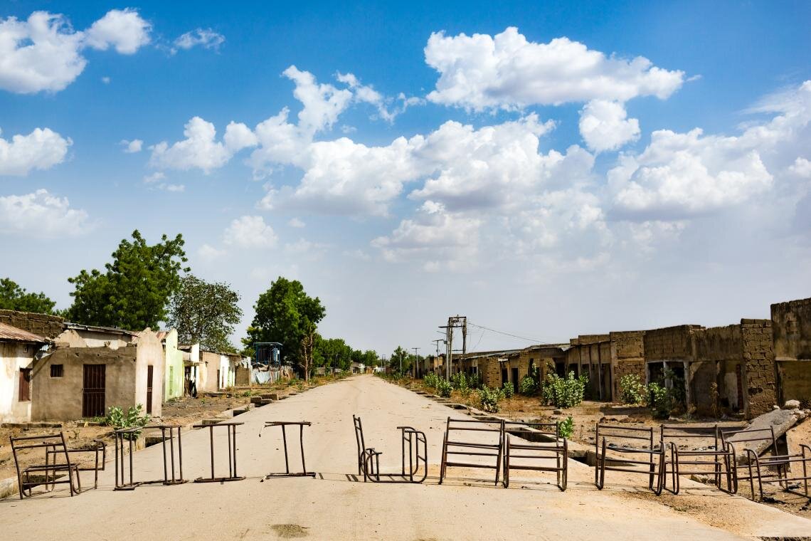 A row of old desks lies across the road on the outskirts of Banki, Nigeria on 1 May 2019. Although the town is still considered one of the most dangerous places in Borno State and is largely deserted, its local primary school has reopened. Refurbished with support from UNICEF, it now has a high perimeter wall, entry and exit gates, and teachers who have been trained to provide psychosocial support.