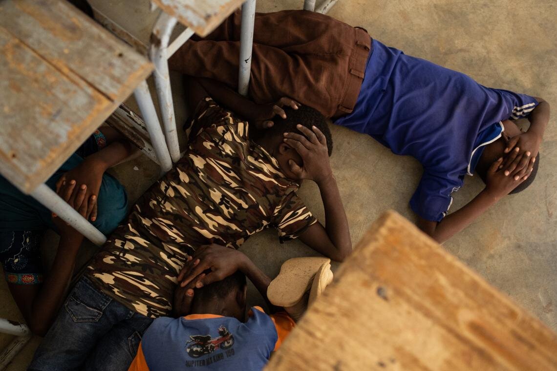 Children take part in an emergency attack simulation and practice sheltering in the event of an assault, at the Yalgho Primary School in Dori, Burkina Faso on 26 June 2019. Threats to teachers, ambushes on schools and the use of schools for military purposes have forced 4,505 schools in the country to close, disrupting education for more than 626,693 children.