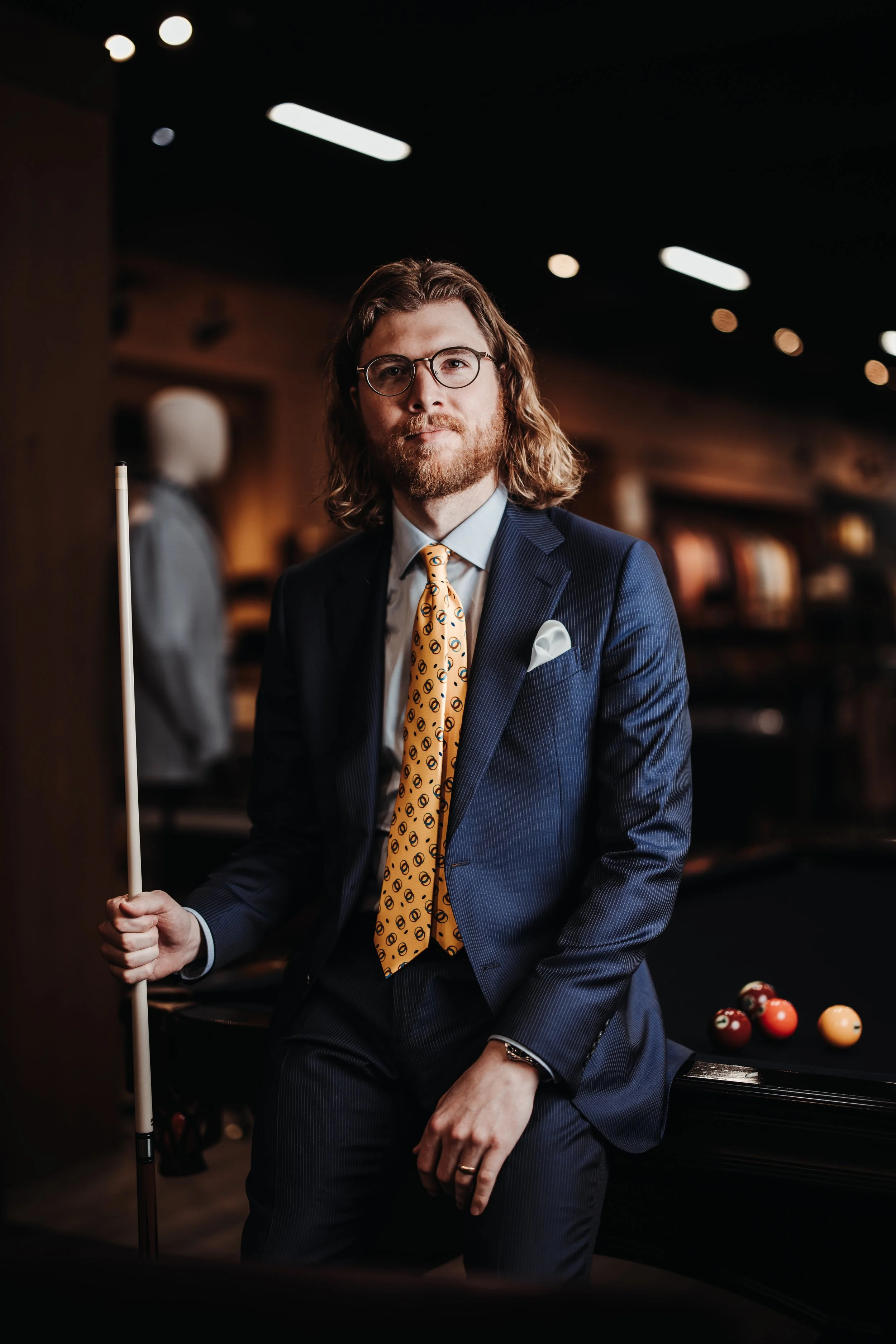 a man posing in a suit from the UWM Men's Shop.