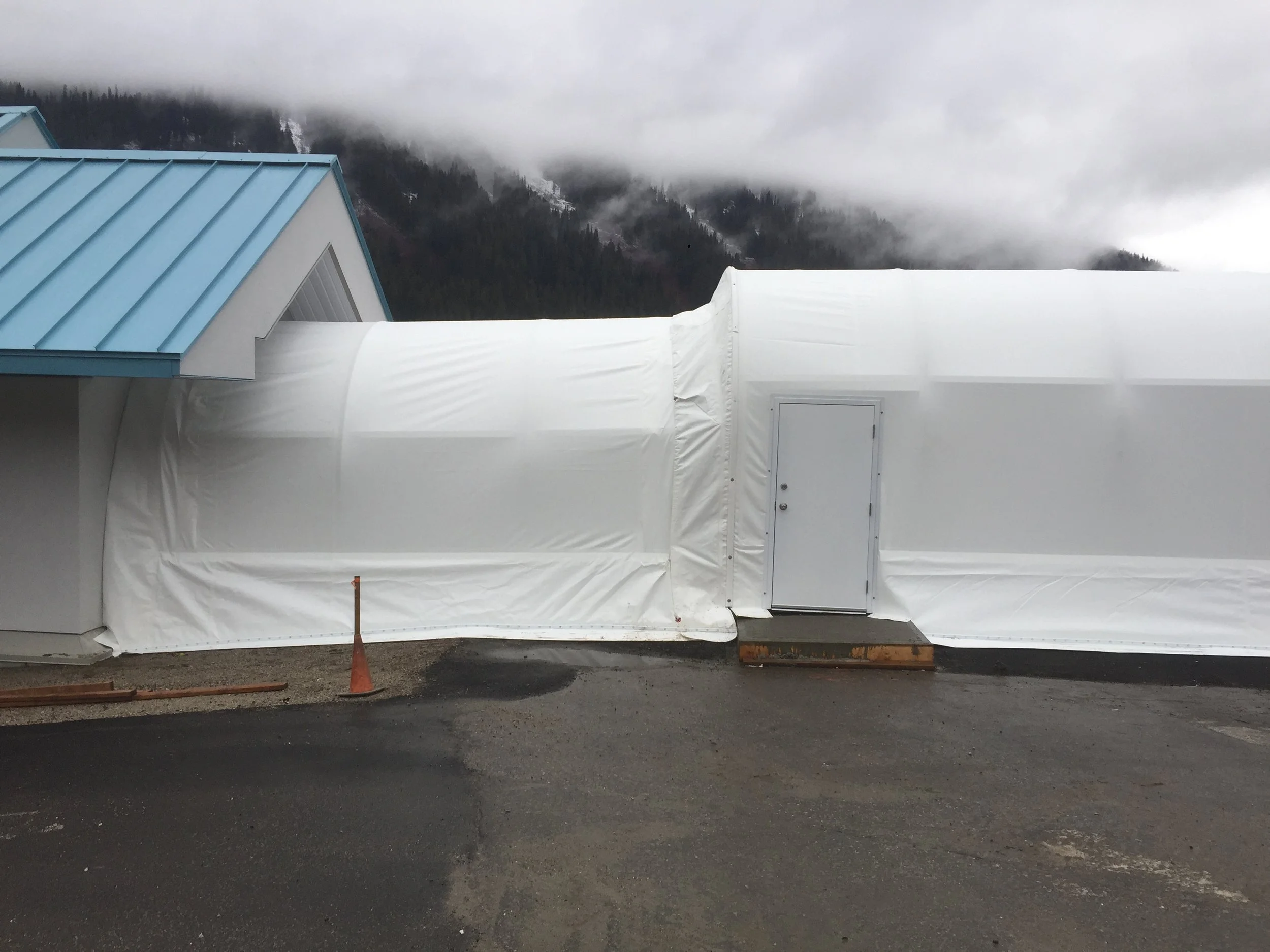 Side view of custom fabric building project that is attached to a larger building