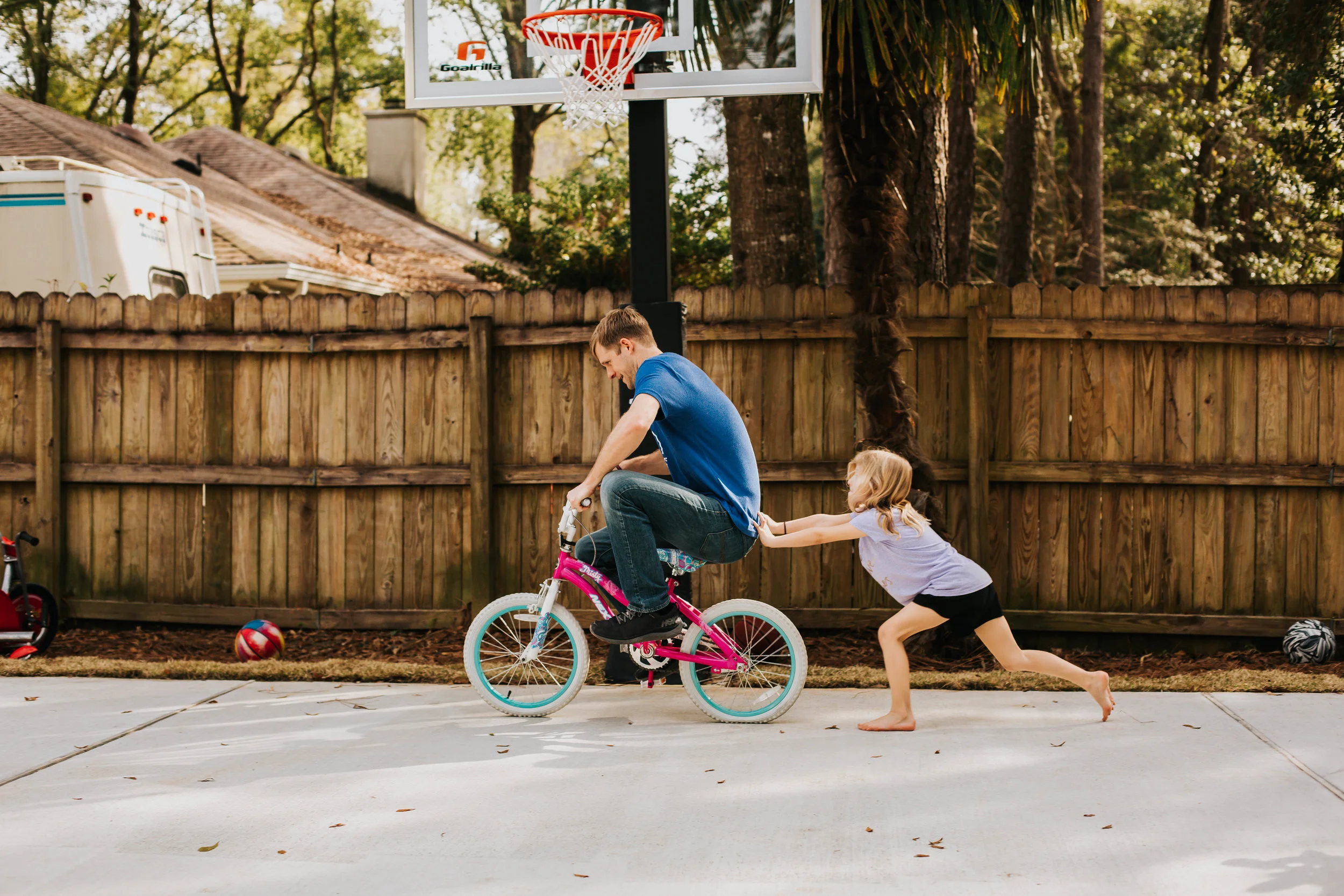 girl pushing daddy on bike in Fairhope Alabama