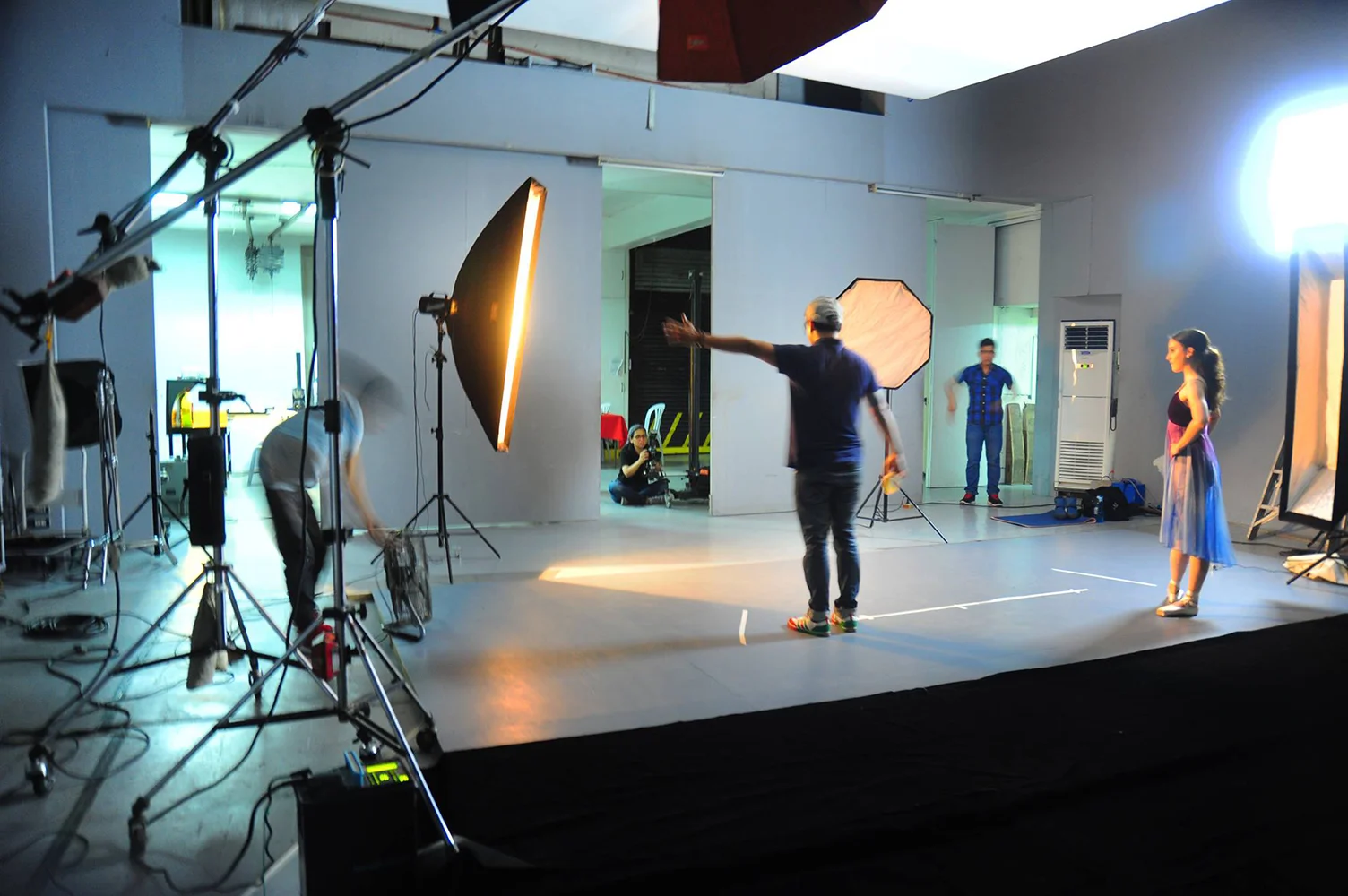 Behind the scenes, Katherine Barkman (right) waits to execute her routine as photographer G-nie Arambulo (seated, center) confers with her staff. 