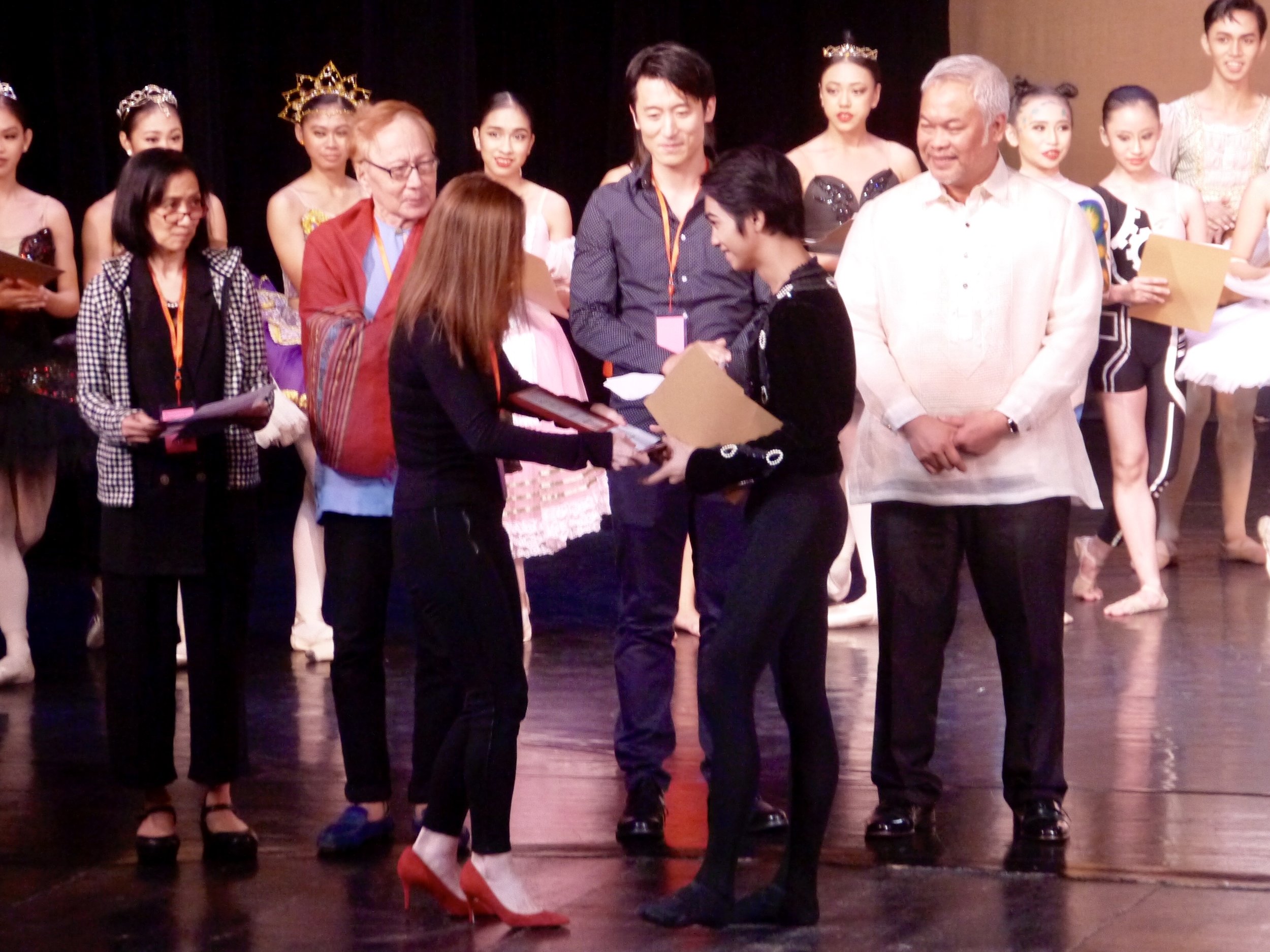 Juror Melanie Motus congratulates third-placer Alvin Dictado as jurors (from left) Myra Beltran, Eddie Elejar, Qi Han and CCP vice president and artistic director Chris Millado look on.