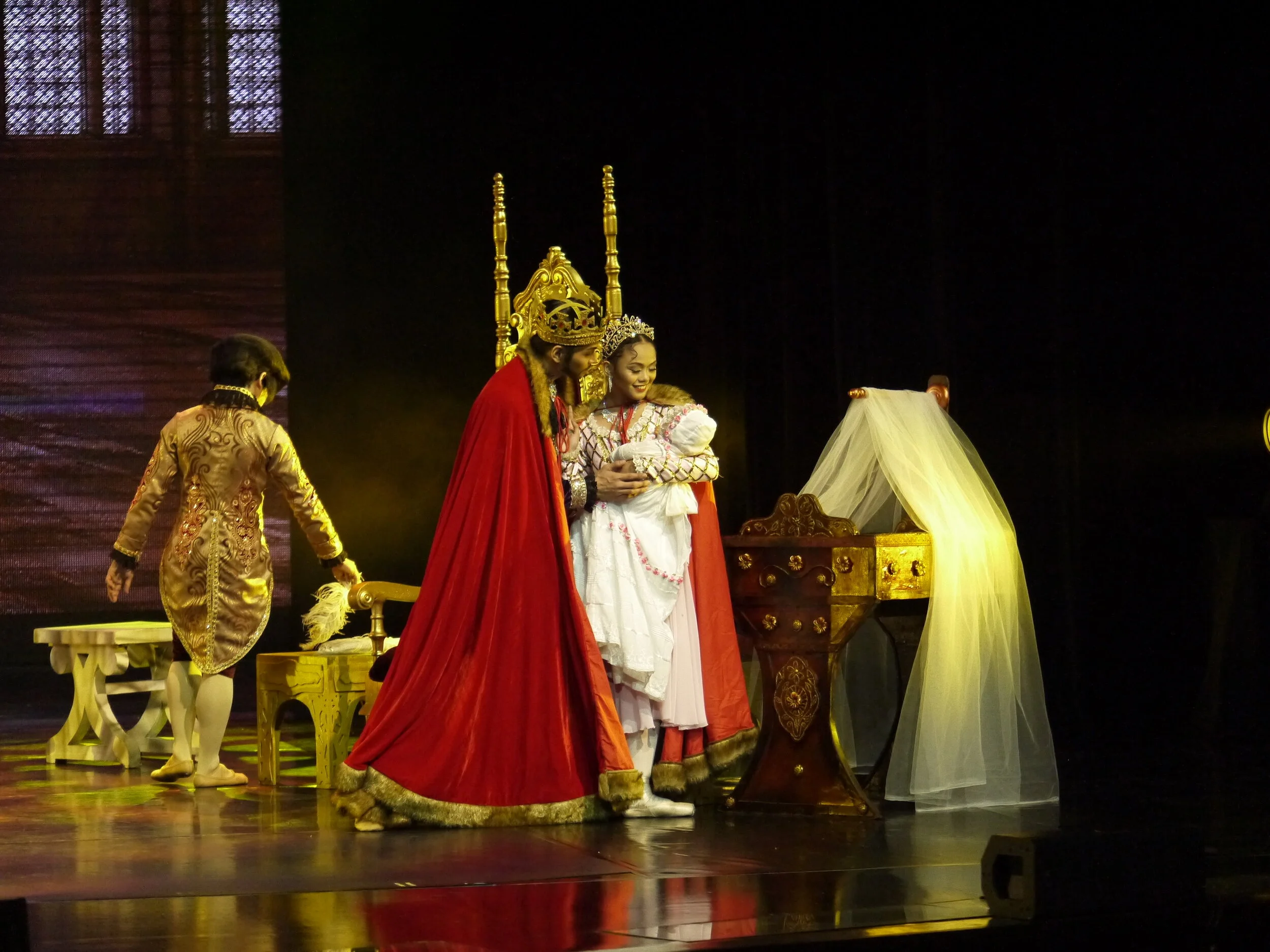   Rissa May Camaclang is the picture of happiness as the mother of Aurora in  Sleeping Beauty  as she and the king (Mark Sumaylo) prepare for their daughter’s christening. Photo by Giselle P. Kasilag   