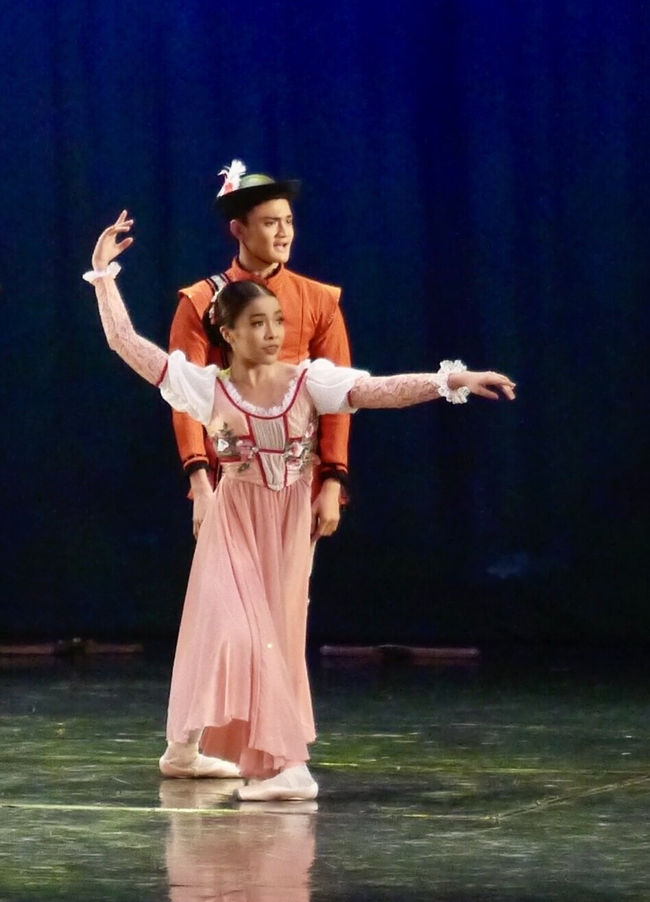    Nicole Barroso wears a rose-colored outfit that matches her pink pointe shoes as one of the ladies in the hunting party in 2019’s  Snow White.  With her is Joshua Enciso as a hunter, clad in orange. Photo by Giselle P. Kasilag   