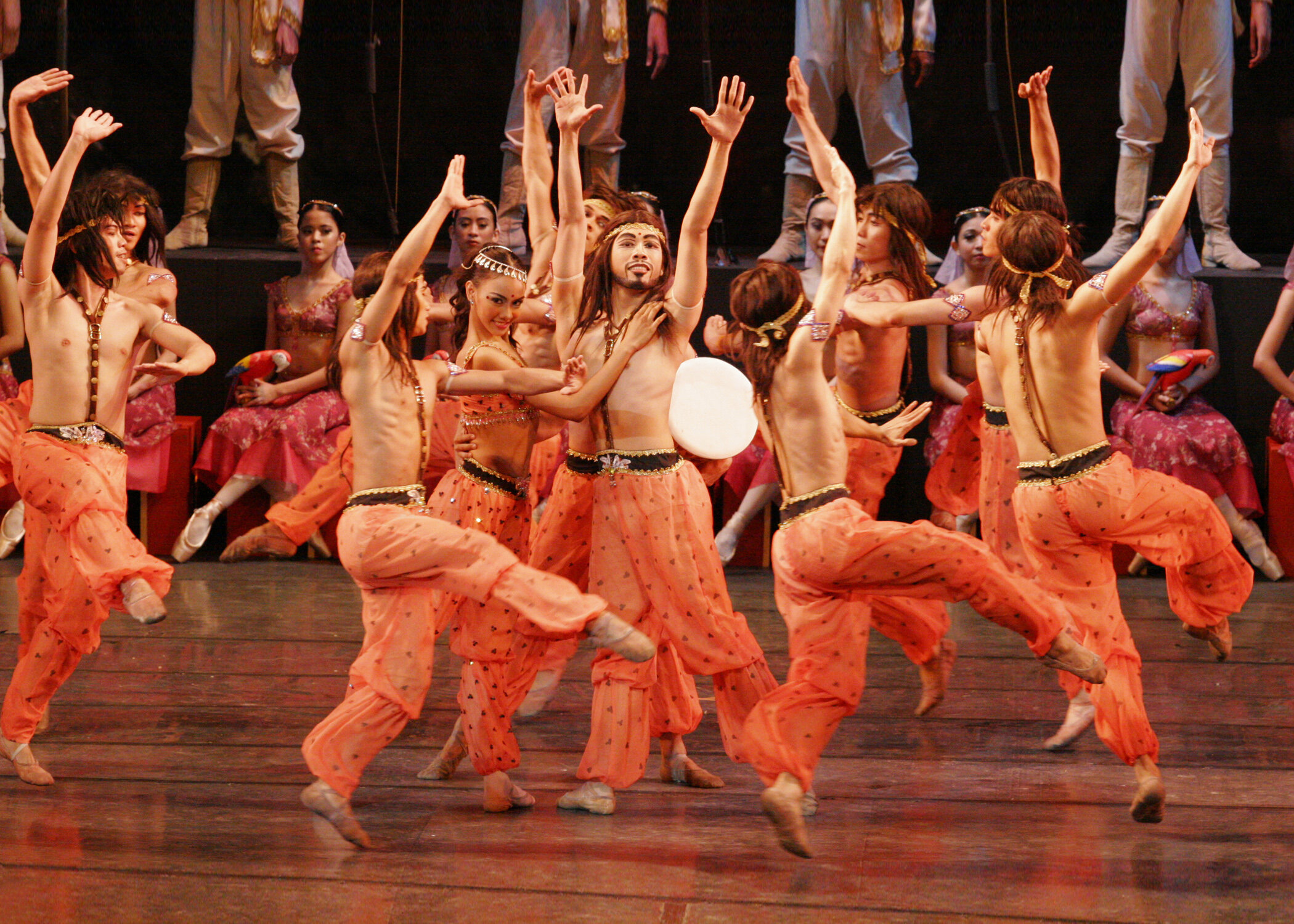    A grand celebration is held at the palace for the betrothal of Solor and Gamzatti in  La Bayadere  (2004). The festivities begin with a pulsating number from these merrymakers in flamboyant orange. Photo by Ocs Alvarez   