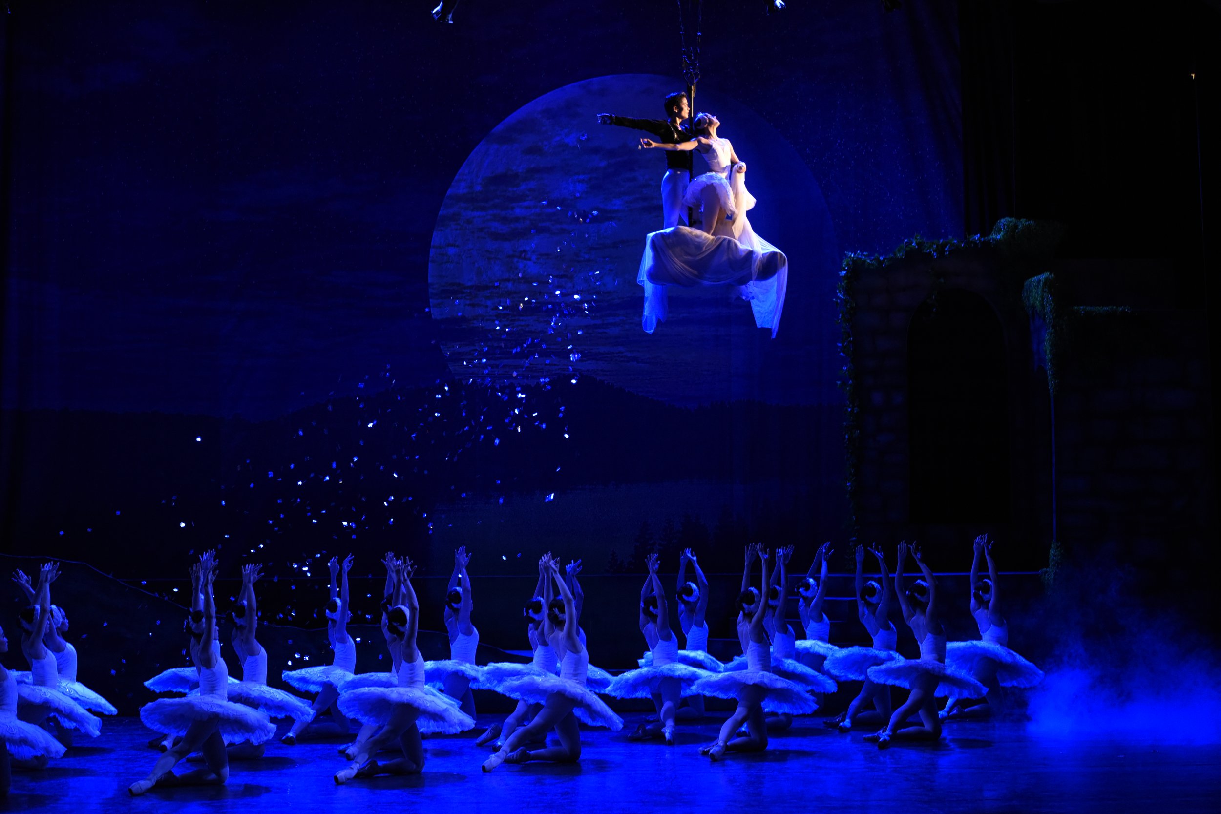    Bathed in the surreal glow of the moon, Odette (Katherine Barkman) and Prince Siegfried (Elpidio Magat) flee, with the enchanted swan maidens below appearing to send them off in  Swan Lake  (2019). After realizing the sorcerer Von Rothbart has tri