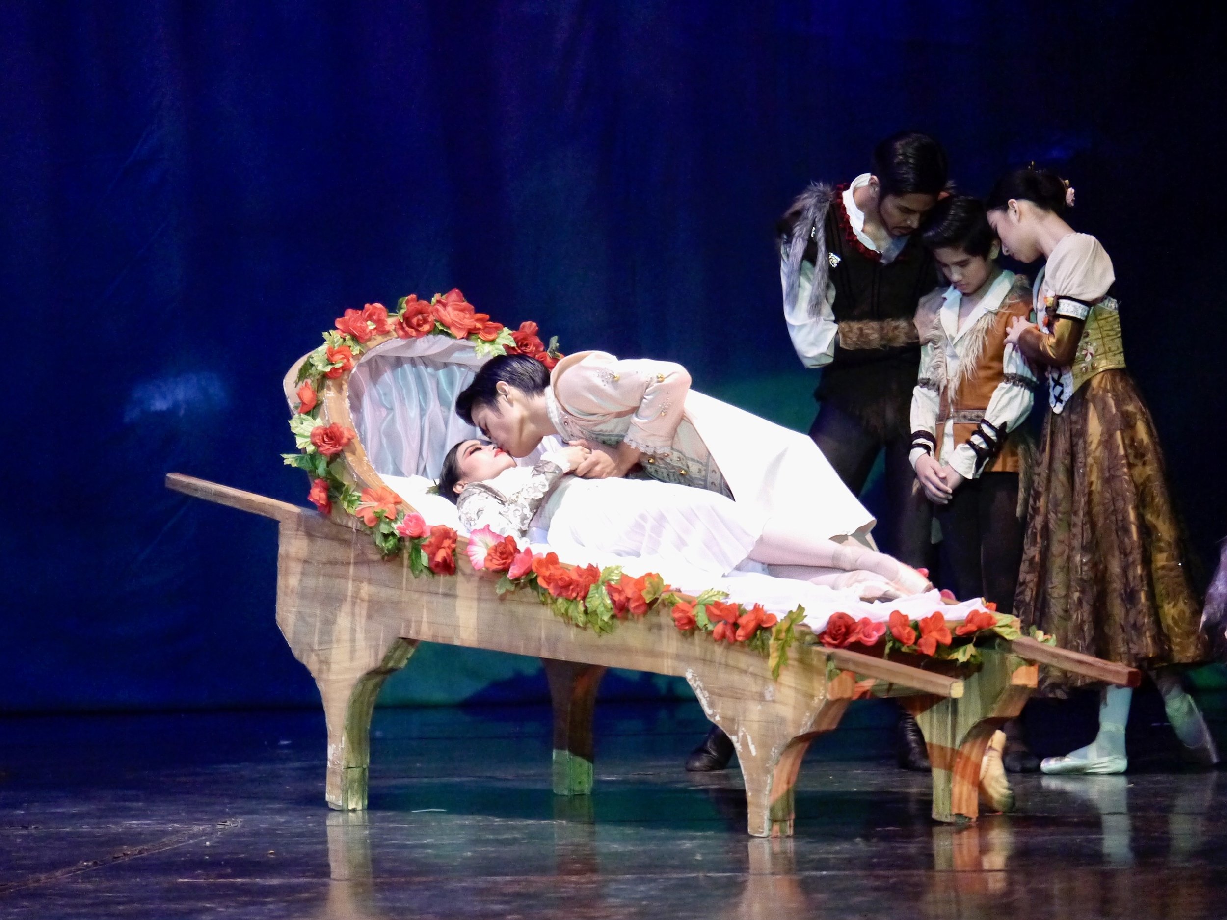    After taking a bite of the poisoned apple, the heroine in Lisa Macuja-Elizalde’s  Snow White  (Joan Emery Sia), restaged in 2019, falls into a sleeping death. Laid on a flower-bedecked resting place in the middle of a forest, the huntsman and his 