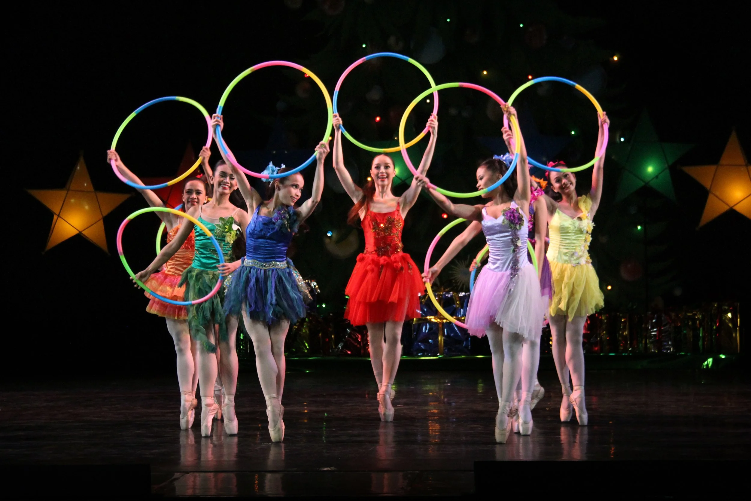   These ballerinas, wearing tutus of different colors and carrying neon-hued hoops, make  Paskong Darating  a delightful dance.&nbsp;  