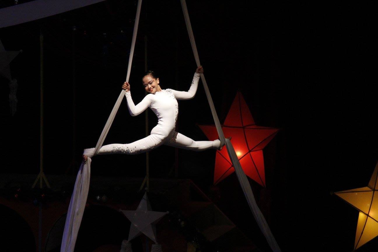    This young girl makes being an aerialist look so easy in one of the numbers cheered by the Christmas crowds..   